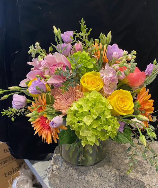 Mixed bouquet in a glass vase with yellow roses and pink lilies