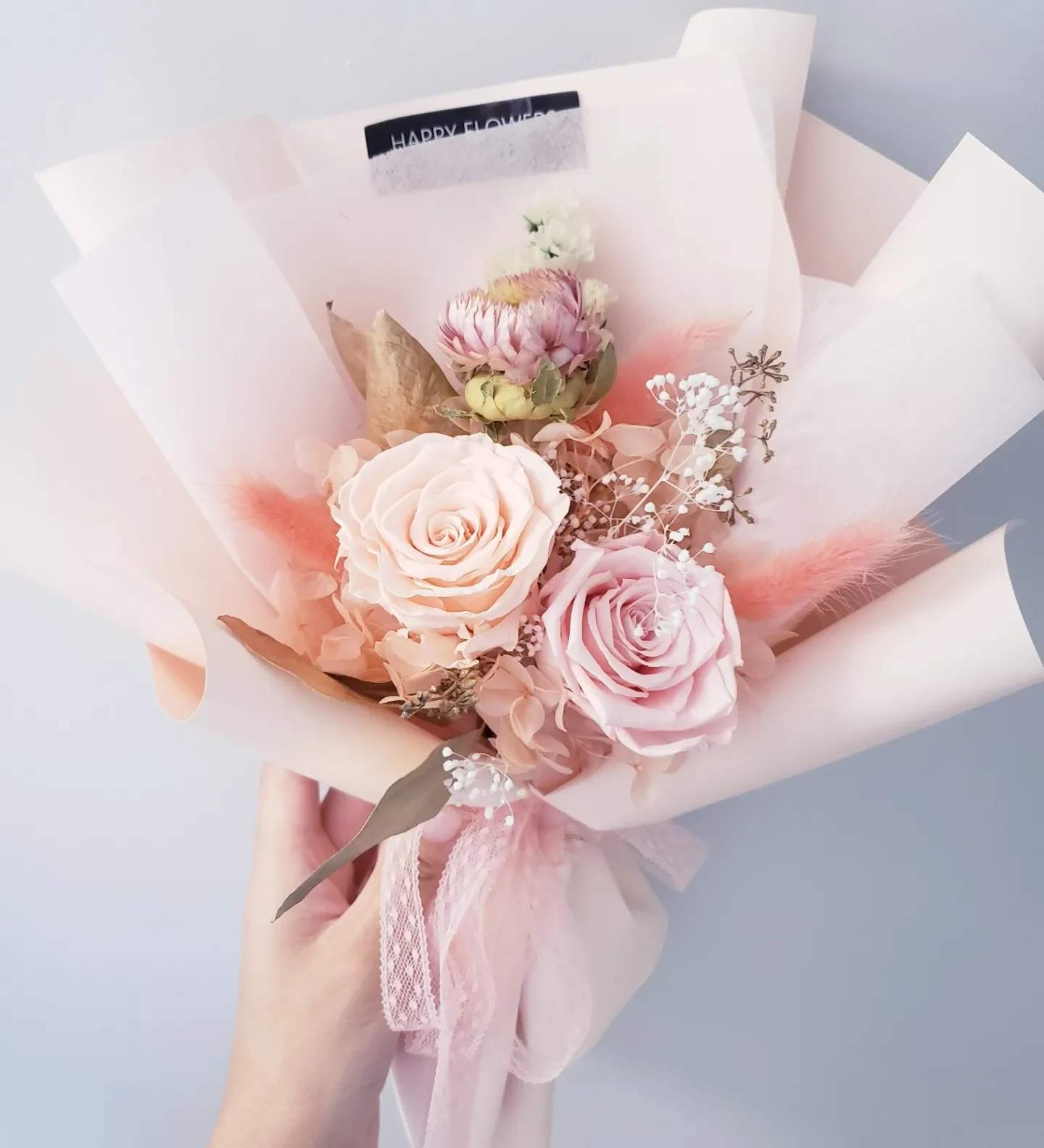 Pink and cream rose bouquet wrapped in pale paper