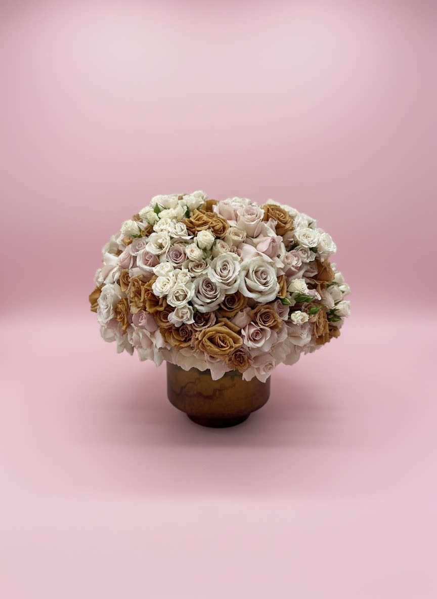 Toffee &amp; Blush Bloom - A timeless, luxurious arrangement featuring premium blush, ivory, champagne, and toffee roses accented with delicate spray roses and soft hydrangeas. Designed in a warm bronze keepsake vase, this elegant centerpiece offers a romantic garden-inspired look with rich texture and graceful color transitions. Perfect for sympathy, anniversaries, birthdays, or as a sophisticated statement piece for the home.