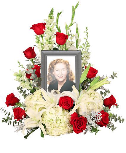 Missing You - Honor and celebrate the fruitful life of a lost loved one with an arrangement that truly encompasses their elegance. The Missing You memorial arrangement is a luxurious addition to any memorial service. Encompassing the picture of your choice, this arrangement features majestic white hydrangeas that will ease the minds and comfort the souls that are grieving with contrasting red roses to represent the vibrance of their life. Picture Frame Not Included  Includes Large Wet Floral Foam Cage, Foliage: Eucalyptus (Baby Blue), Sword Fern, Dusty Miller, Red Roses, White Snapdragons, White Gladiolus, White Larkspur, White Hydrangea, White Lilies.