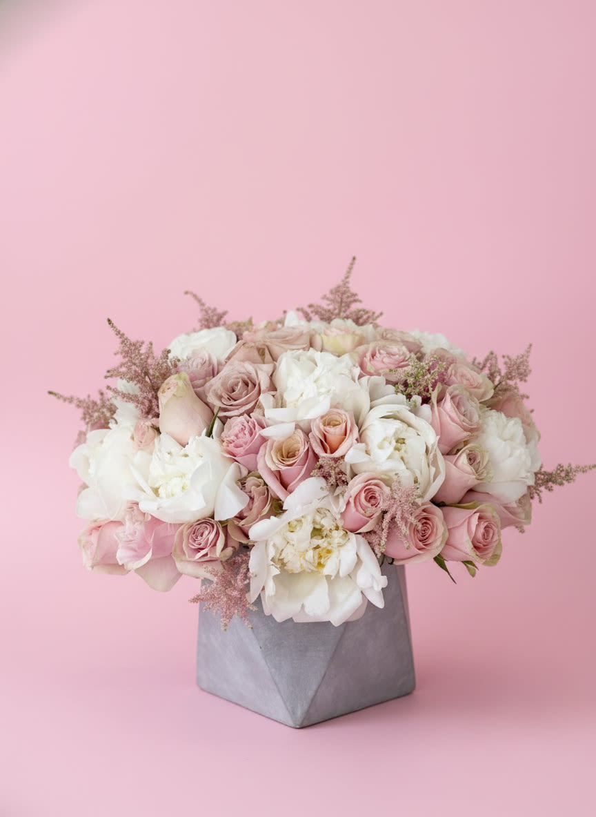 Pure Romance - A graceful blend of blush and ivory blooms, Blush Elegance is designed to bring timeless beauty to any occasion. Featuring luxurious peonies, premium blush roses, garden roses, and delicate astilbe, this lush arrangement is artfully arranged in a modern concrete vase for a sophisticated finish. Its soft, romantic palette makes it a perfect gift for birthdays, anniversaries, baby showers, sympathy gestures, or simply to brighten someone’s day with elegance and charm.