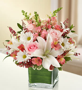 Healing Tears - Pink and White - Product ID: 95390  The elegant of our pink and white arrangement conveys your heartfelt condolences to friends and family. Gathered in a lovely cube vase by our florists, pink roses, snapdragons and heather mix with graceful white lilies and daisy poms to present a tasteful tribute. Elegant arrangement of fresh pink roses, pink snapdragons, white lilies, pink alstroemeria, white daisy poms and pink heather, accented with variegated pittosporum and myrtle Artistically designed by our florists in a classic clear glass cube vase lined with a Ti leaf ribbon; vase measures 5"H x 5"D Appropriate for the service or for sending to the home or office of friends and family members Large arrangement measures approximately 11"H x 11"L Medium arrangement measures approximately 10"H x 10"L Small arrangement measures approximately 9"H x 9"L Our florists hand-design each arrangement, so colors, varieties, and container may vary due to local availability Lilies may arrive in bud form and will open to full beauty over the next 2-3 days