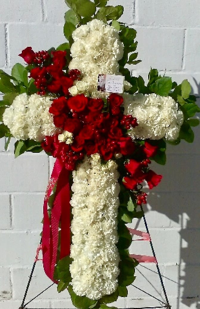 Cross-shaped floral tribute with red roses and white carnations