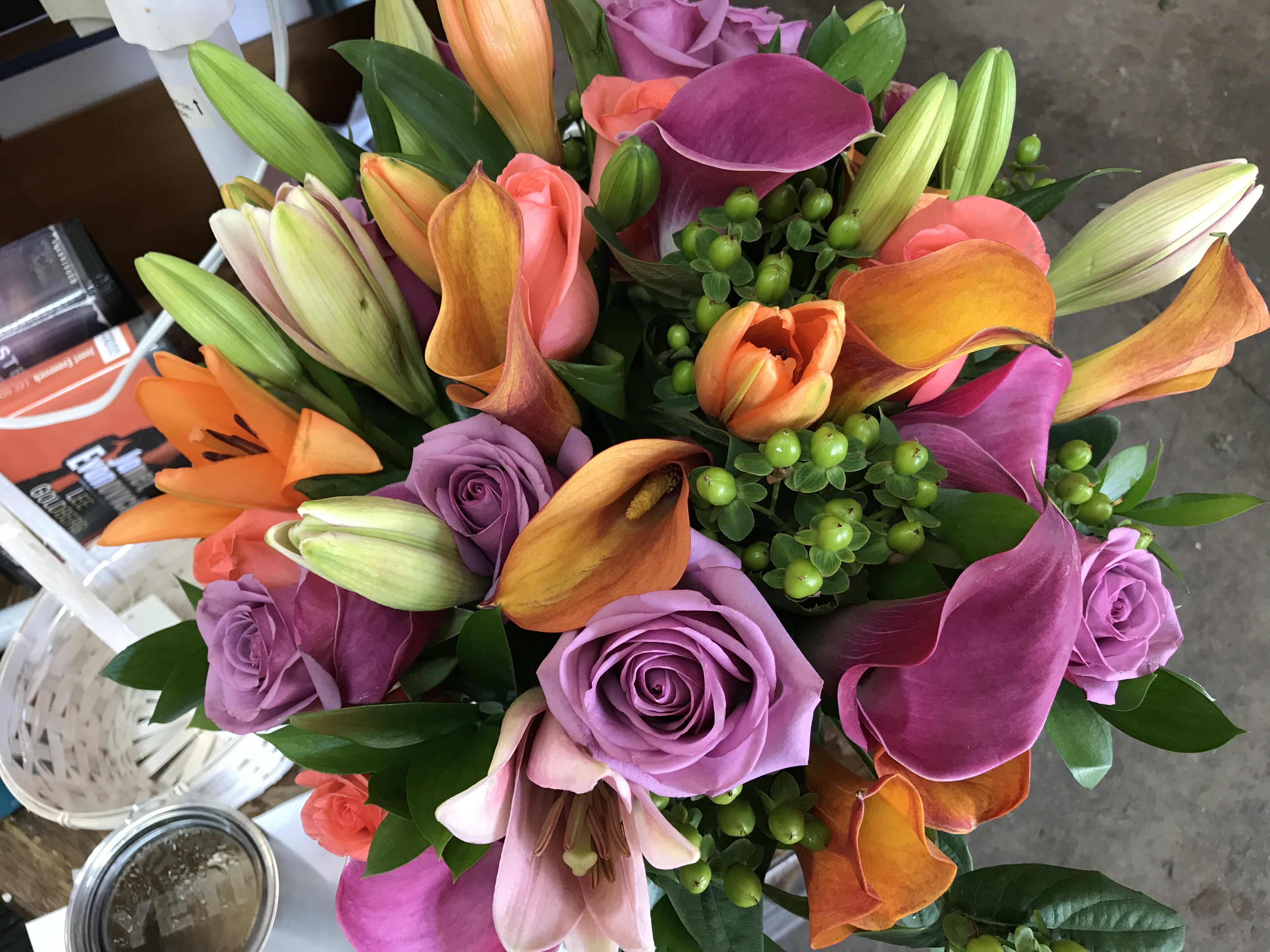 Bouquet of purple roses, orange lilies, and pink calla lilies