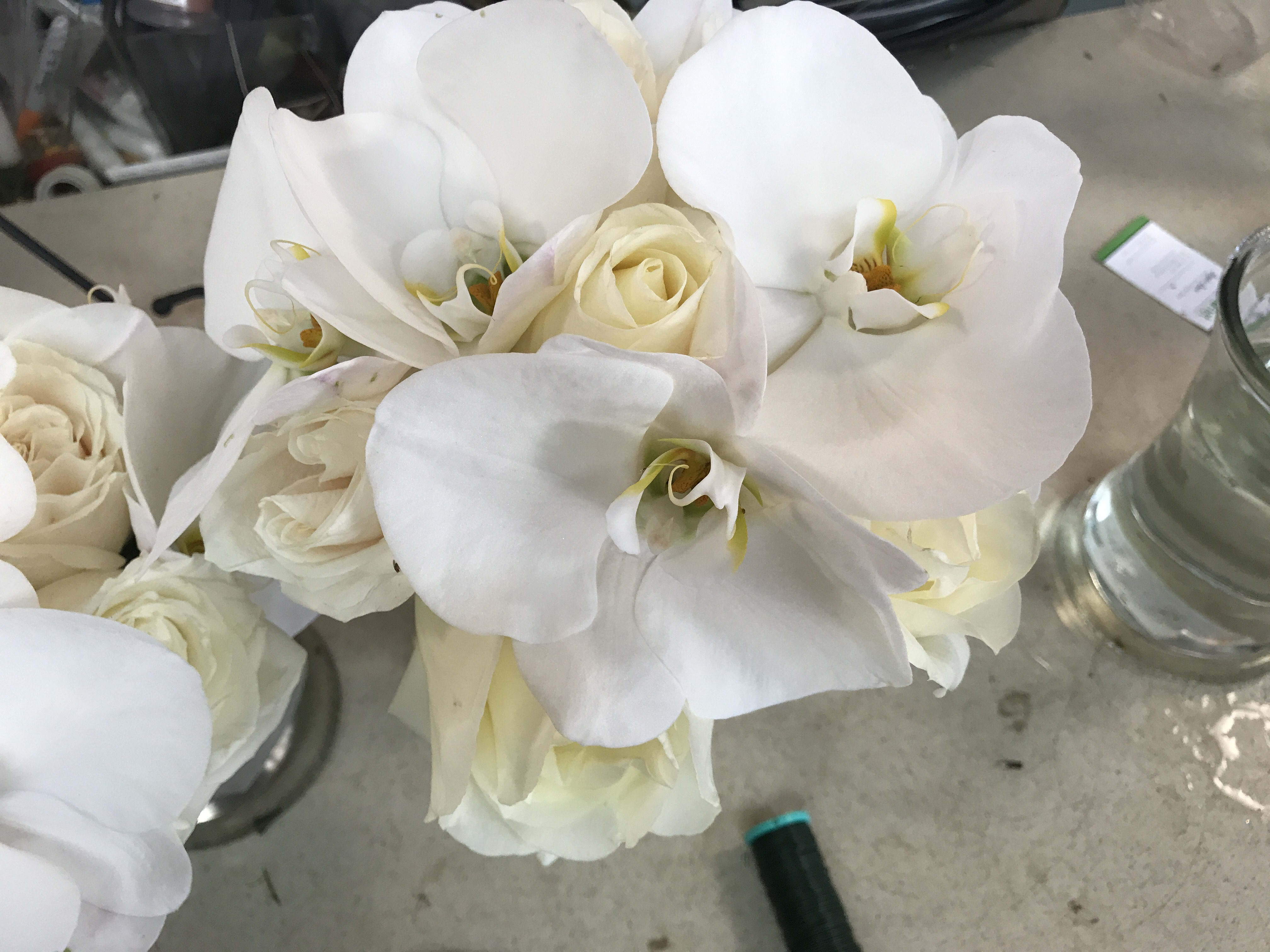 White orchids and cream roses in a bouquet