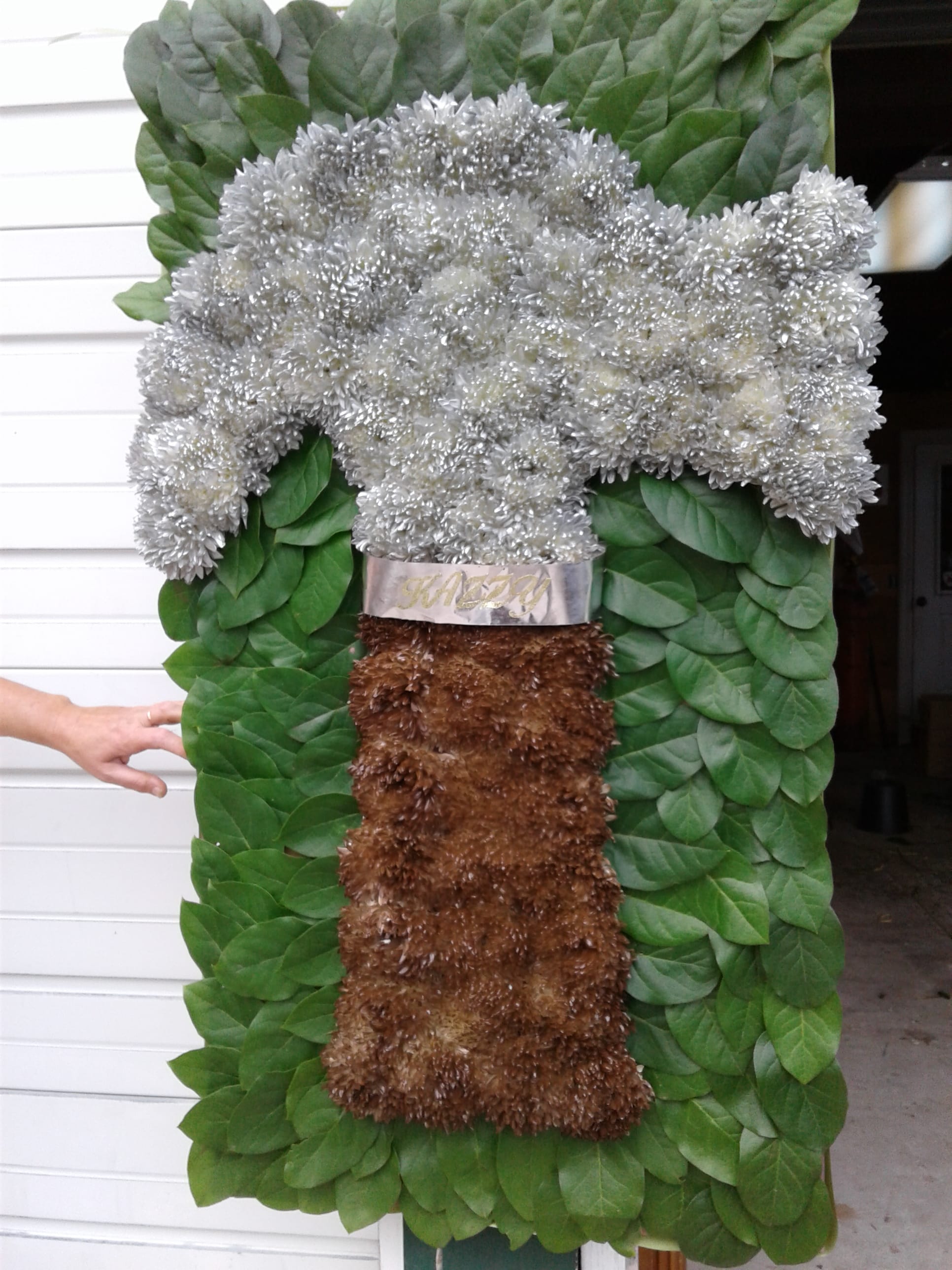 Large floral standing spray with silver blooms and green foliage