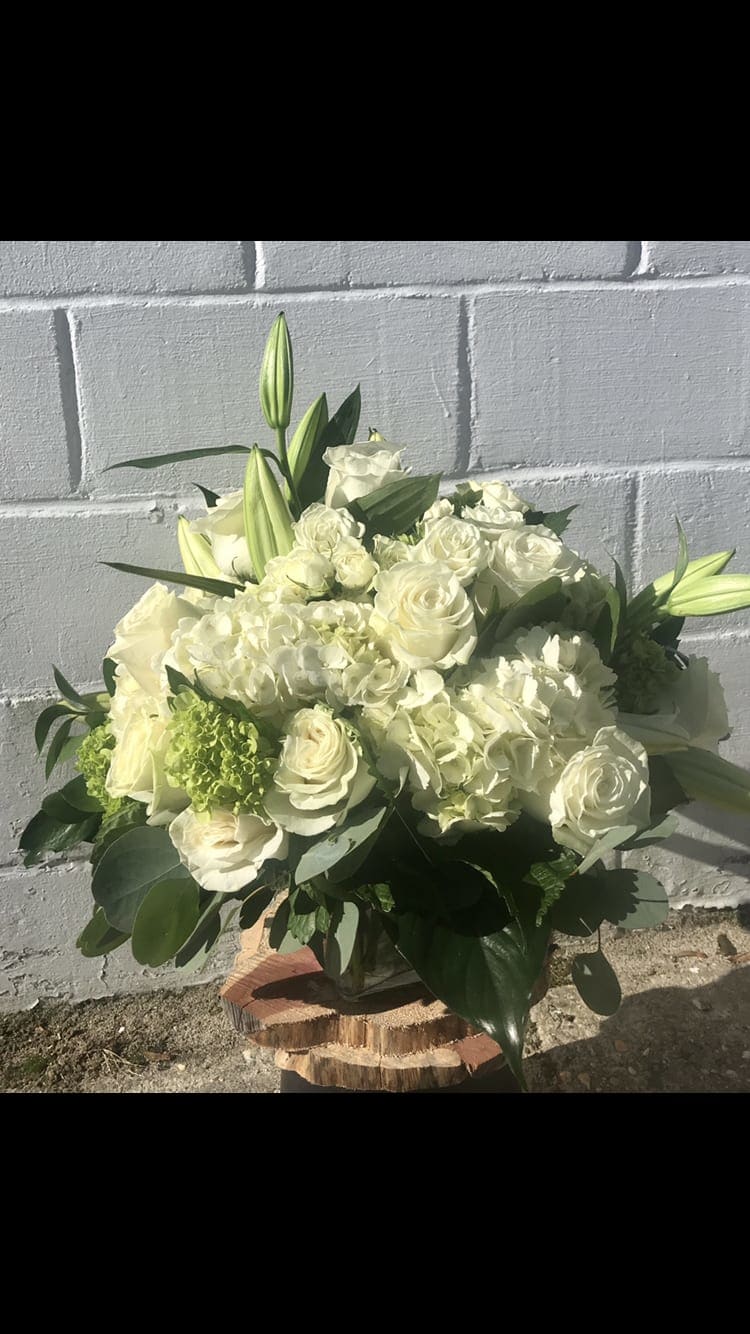 White roses and lilies arranged in a low bouquet