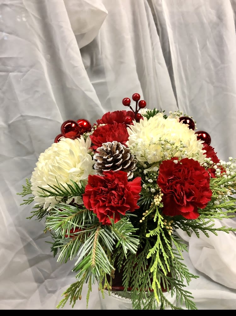 Holiday bouquet of red and white flowers with a pinecone and evergreen accents