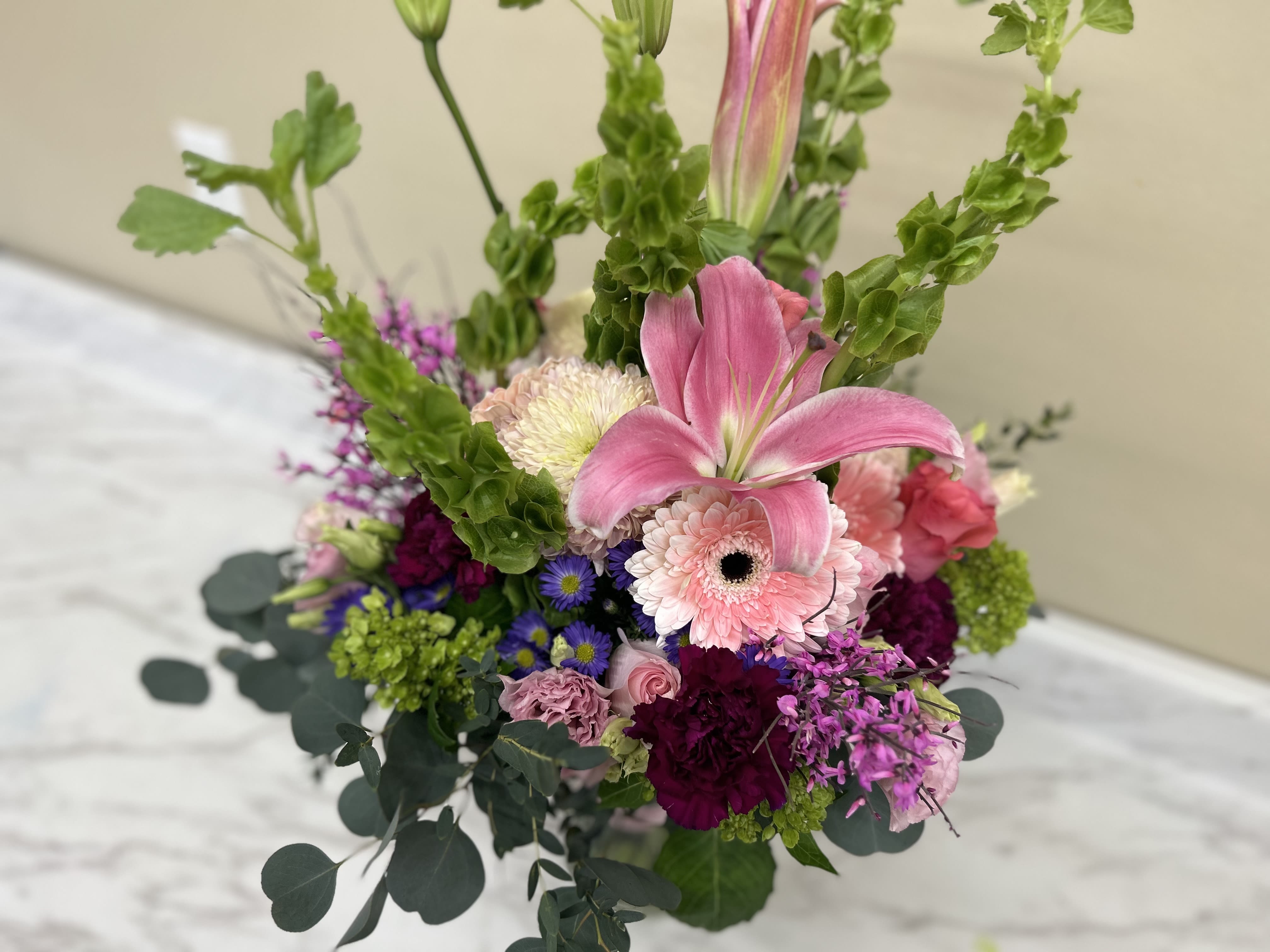 Pink lily and mixed flowers in a vase arrangement