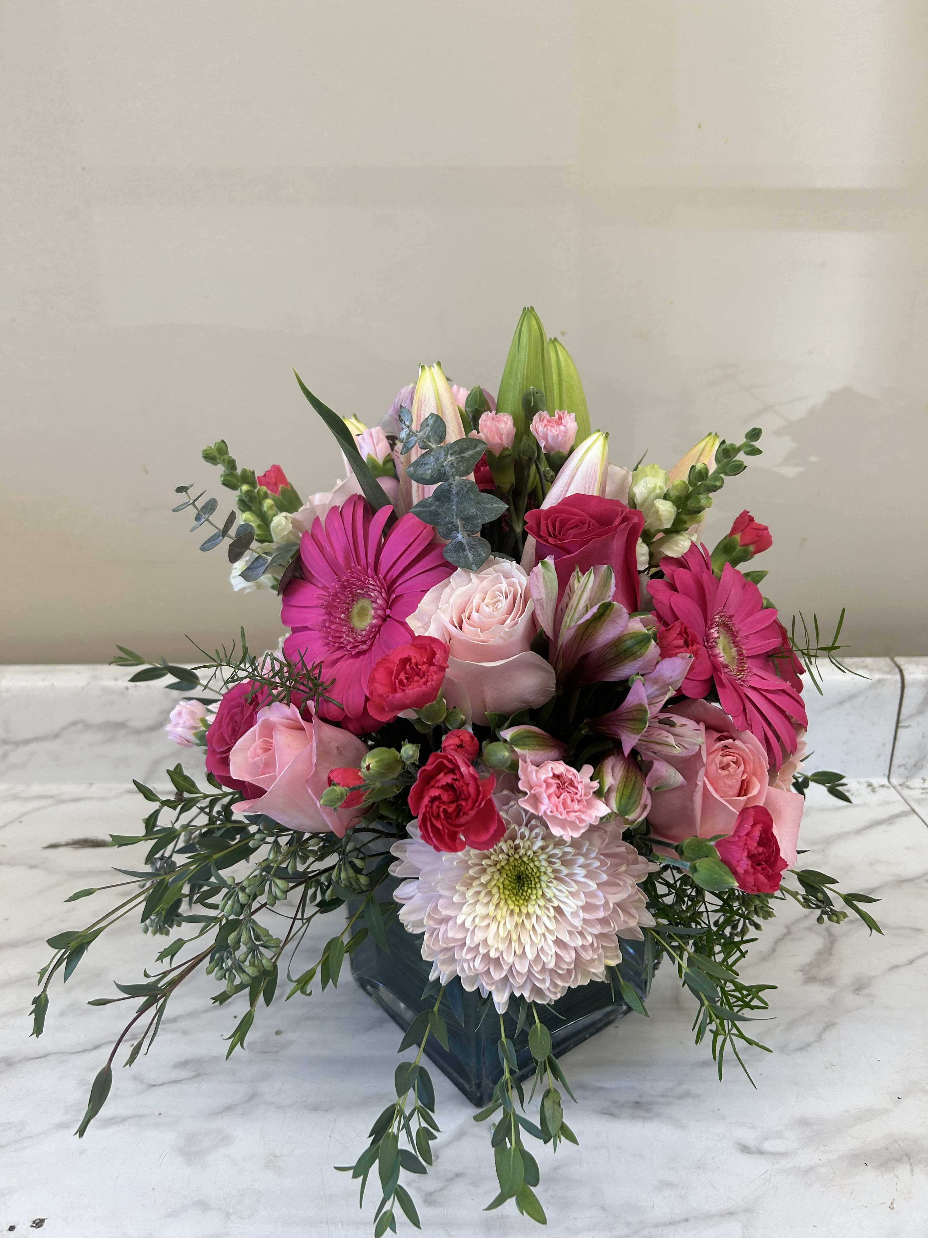 Pink and white mixed bouquet in a dark glass vase
