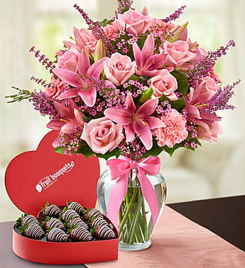 Expressions of Pink with chocolates - Product ID: 107959  There's always a reason to express your feelings in the sweetest way possible! Start with a heart-shaped box of decadent, hand-dipped strawberries to leave them smiling. Then add our hand-arranged bouquet of the freshest pink roses, lilies, carnations and more, for the perfect pair of surprises to celebrate any occasion. A heart-shaped box of chocolates.   Hand-crafted and designed by local shops Delivered fresh to their door with Same-Day Delivery Arrangement of pink roses, lilies, carnations, waxflower and heather, accented with salal Artistically designed inside an 11"H clear glass vase with a stylish decorative ribbon Large arrangement measures approximately 18"H x 11.5"L Medium arrangement measures approximately 17.5"H x 11"L Small arrangement measures approximately 17"H x 10.5"L Our florists hand-design each arrangement, so colors, varieties and container may vary Lilies may arrive in bud form and will open to full beauty over the next 2-3 days