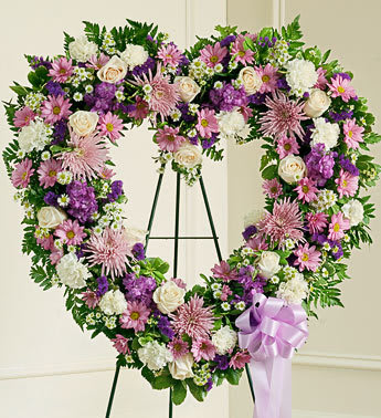 Always Remember Lavender Floral Heart Tribute - Product ID: 91245   The passing of a beloved family member or friend is a sad and difficult time. You want to convey your deepest sympathies to those left behind while also remembering and celebrating a beautiful life. Expertly crafted with delicate lavender and white blooms, this lovely open-heart tribute is a beautiful expression of all the love you feel in your heart. Heart-shaped arrangement of lavender and white flowers such as roses, stock, carnations and more Comes on a wire easel with accents and satin ribbon Appropriate for family and friends to send directly to the funeral home Our florists use only the freshest flowers available, so colors and varieties may vary Measures approximately 30"H x 30"L without easel