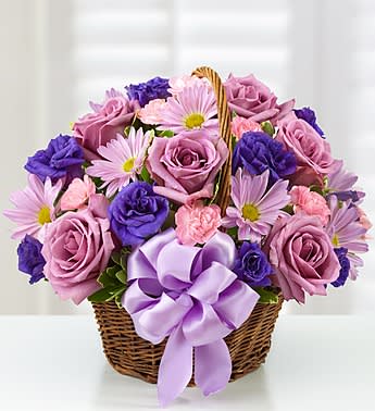Basket of Blooms - Product ID: 105644  Surprise her with a gift in all her favorite colors! Our beautiful arrangement is filled with roses, lisianthus and daisies in rich shades of purple and lavender. Hand-designed in a charming handled basket and accented with a satin ribbon, it's sure to give her the smile she deserves. Beautiful, hand-crafted basket arrangement of lavender roses, purple lisianthus, lavender daisy poms, light pink mini carnations and variegated pittosporum Artistically designed in an 8"H dark willow handled basket accented with a purple satin ribbon Large arrangement measures approximately 13"H x 15"W Medium arrangement measures approximately 12"H x 14"W Small arrangement measures approximately 11"H x 14"W Picked at the peak of perfection delivered fresh to their door Our florists hand-design each arrangement, so colors, varieties and container may vary due to local availability