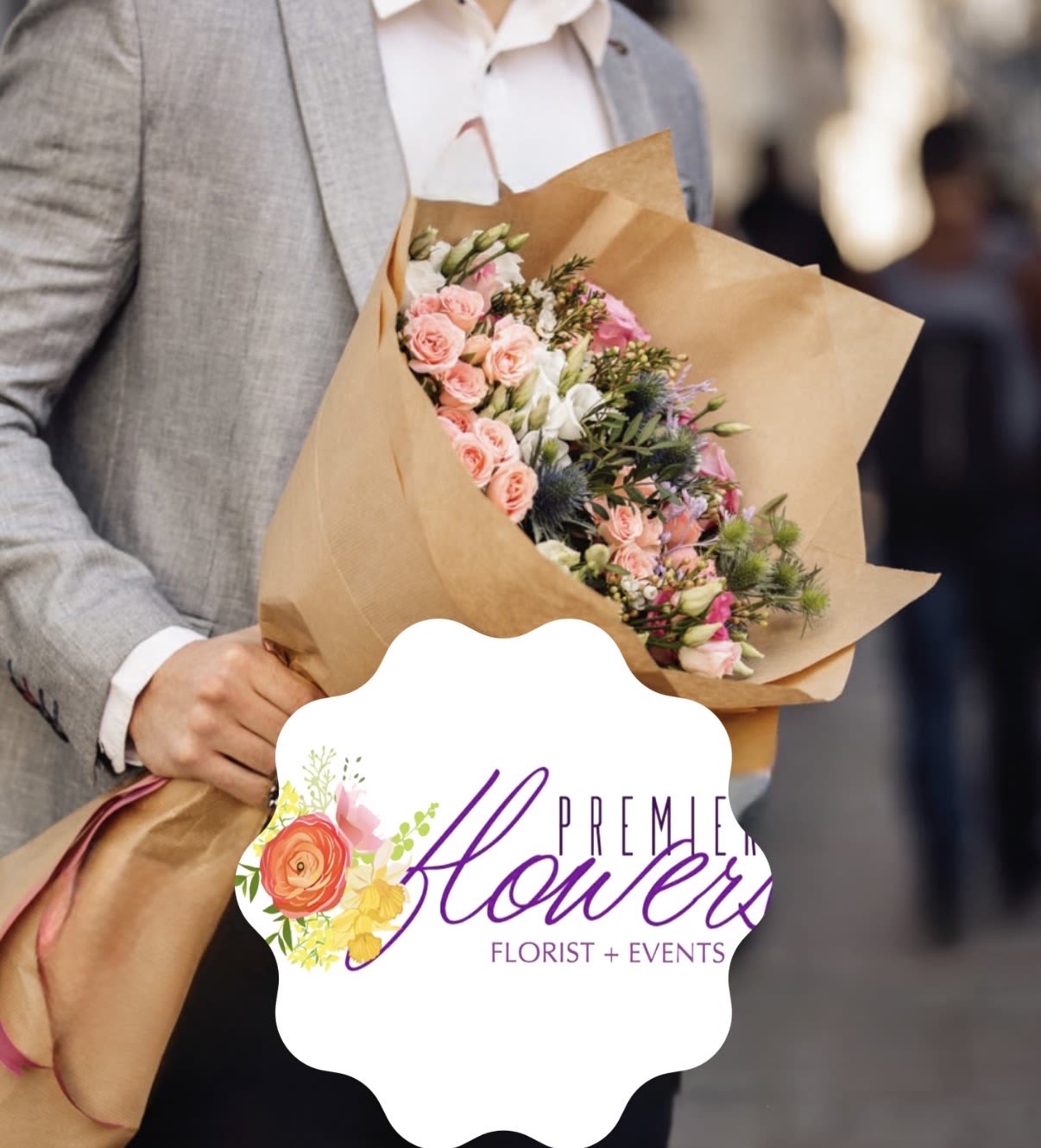 Handheld bouquet of pink and white flowers wrapped in brown paper