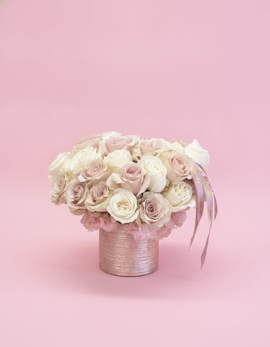 Blush Champagne Luxe - A timeless arrangement of premium blush, ivory, and champagne roses artfully designed in a shimmering blush keepsake hatbox and finished with a signature satin ribbon. Elegant, romantic, and effortlessly luxurious, this arrangement is perfect for birthdays, anniversaries, baby showers, or simply making someone feel cherished. Each design is handcrafted using the freshest premium roses for a full, lush presentation.
