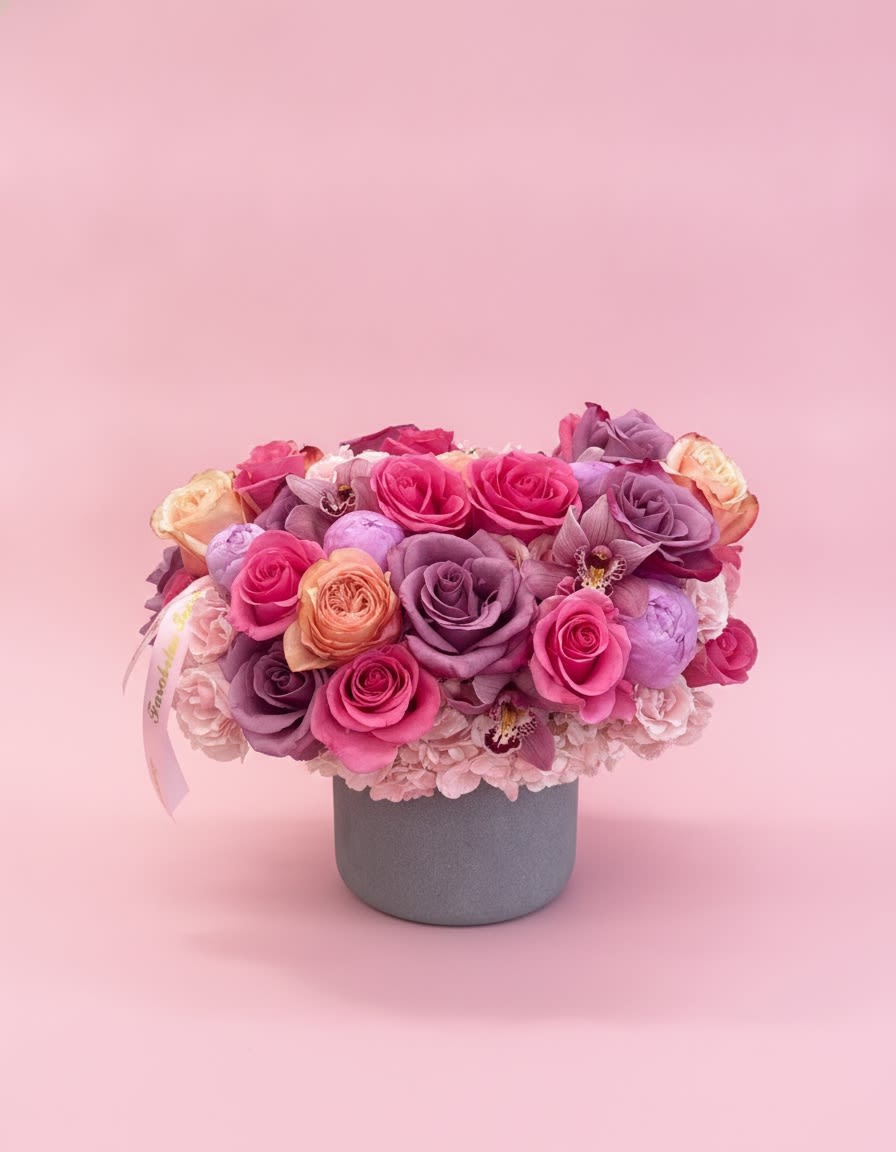 Pink Velvet Dream - A breathtaking luxury floral arrangement featuring premium lavender and hot pink roses, peach garden roses, soft peonies, hydrangeas, and elegant orchids, artfully designed in a modern velvet hat box. A sophisticated statement piece that radiates romance, grace, and timeless beauty—perfect for birthdays, anniversaries, celebrations, or simply making someone’s day unforgettable.