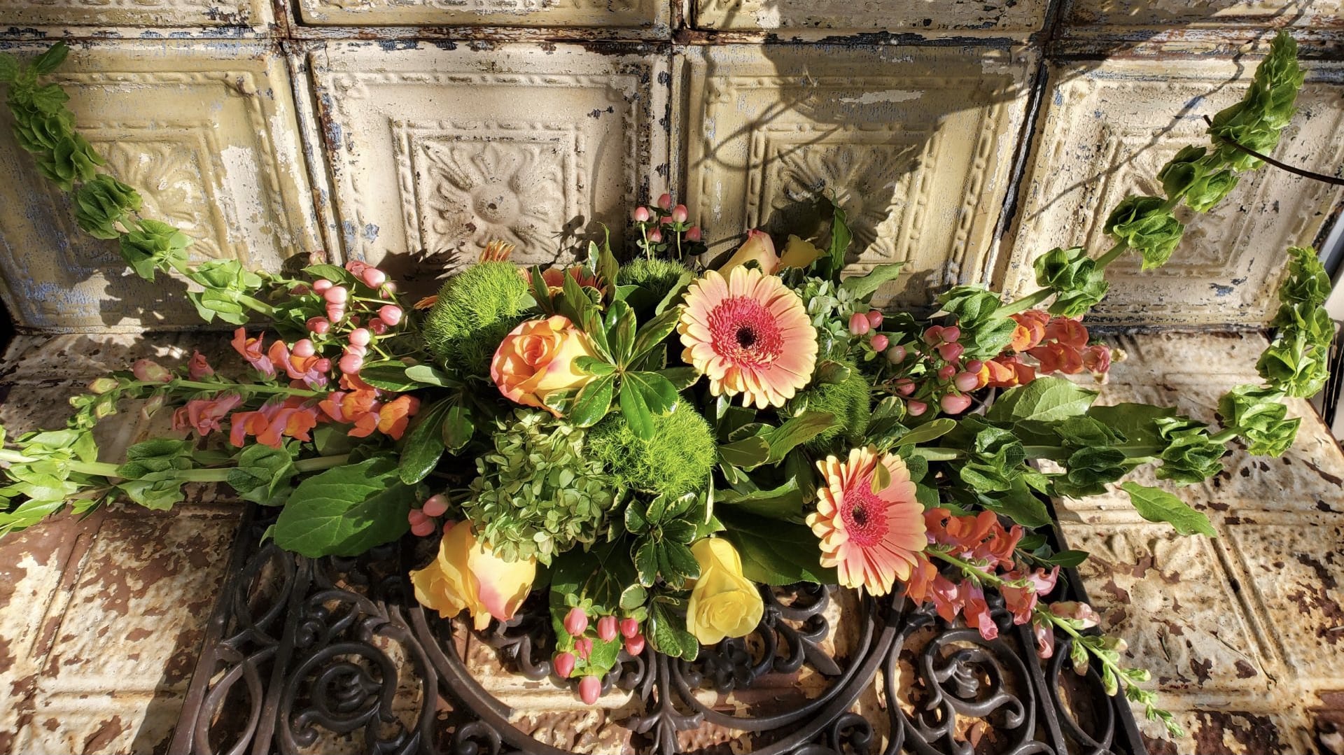 Mixed floral arrangement with pink gerbera daisies and yellow roses