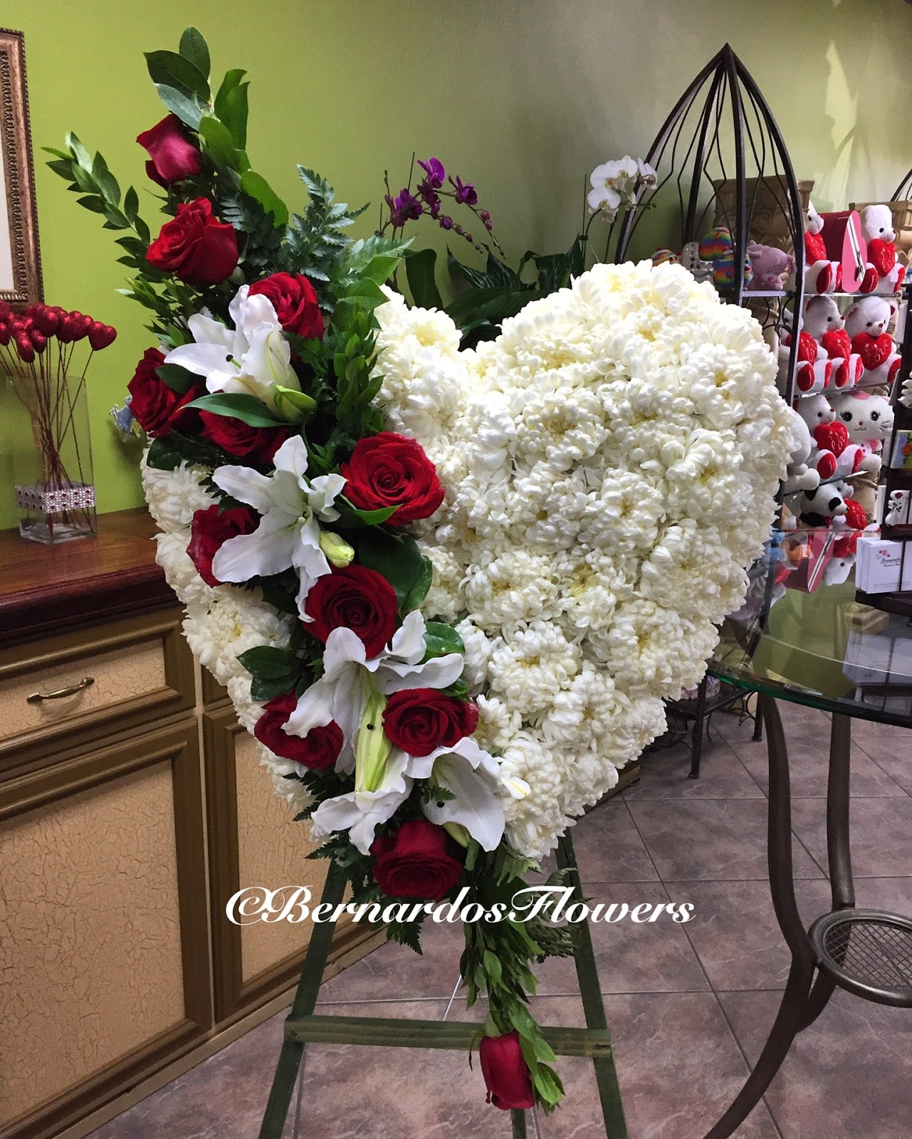 Heart-shaped white floral arrangement with red roses and white lilies