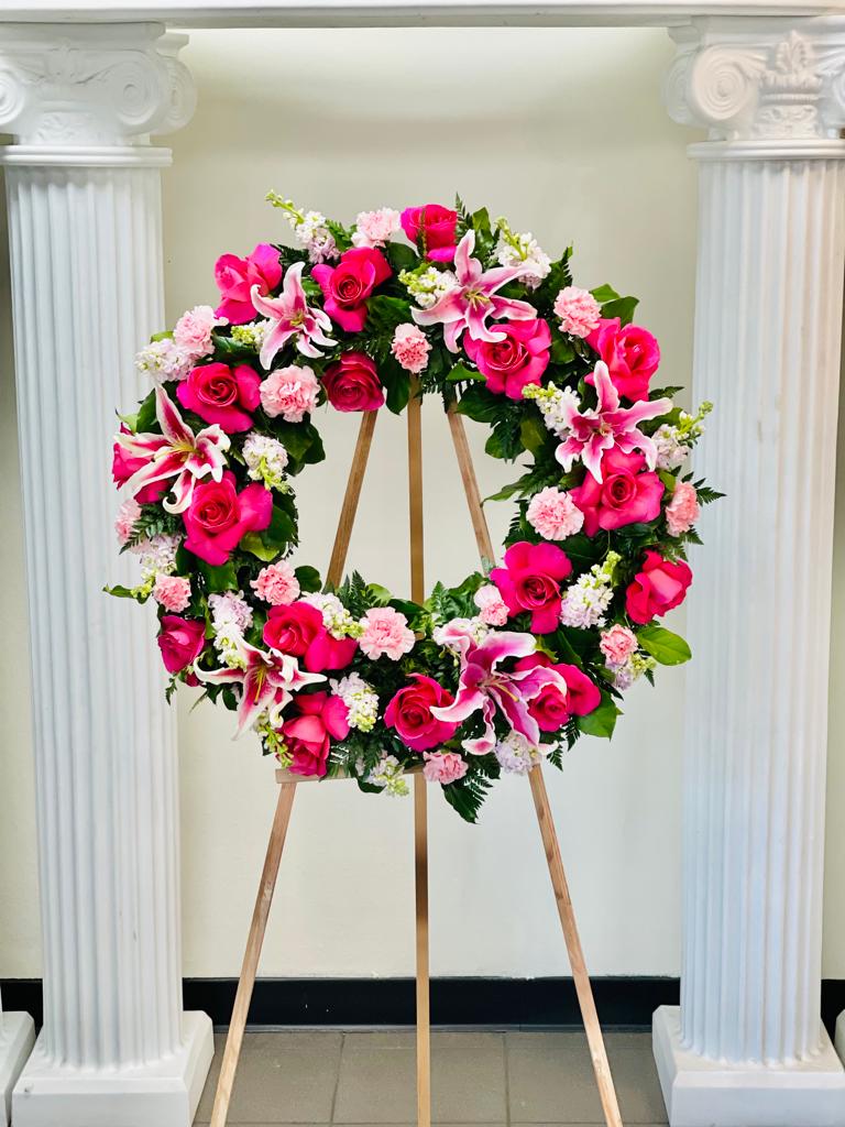 Pink and white floral wreath on a wooden easel