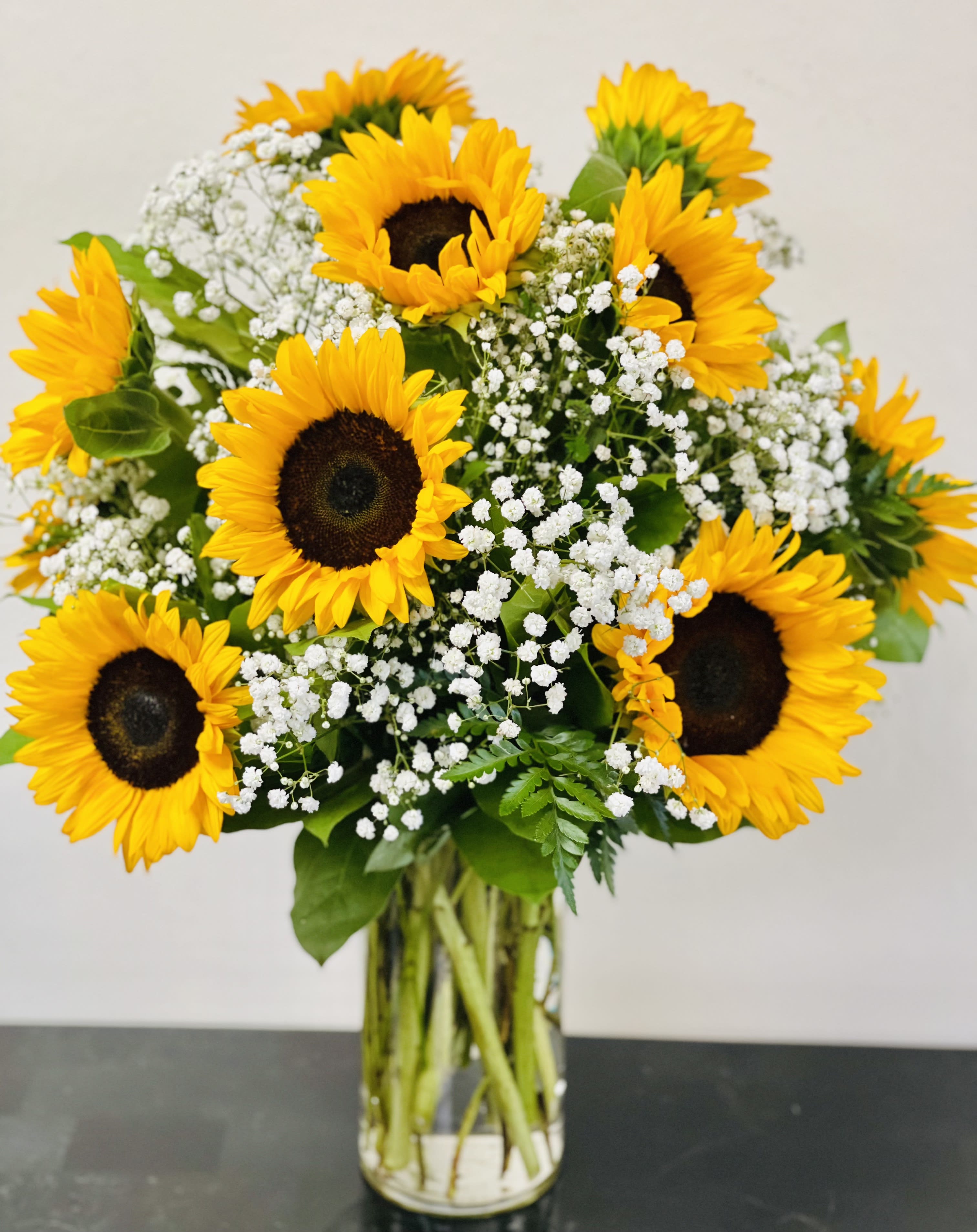 Bouquet of sunflowers and white baby's breath in a glass vase