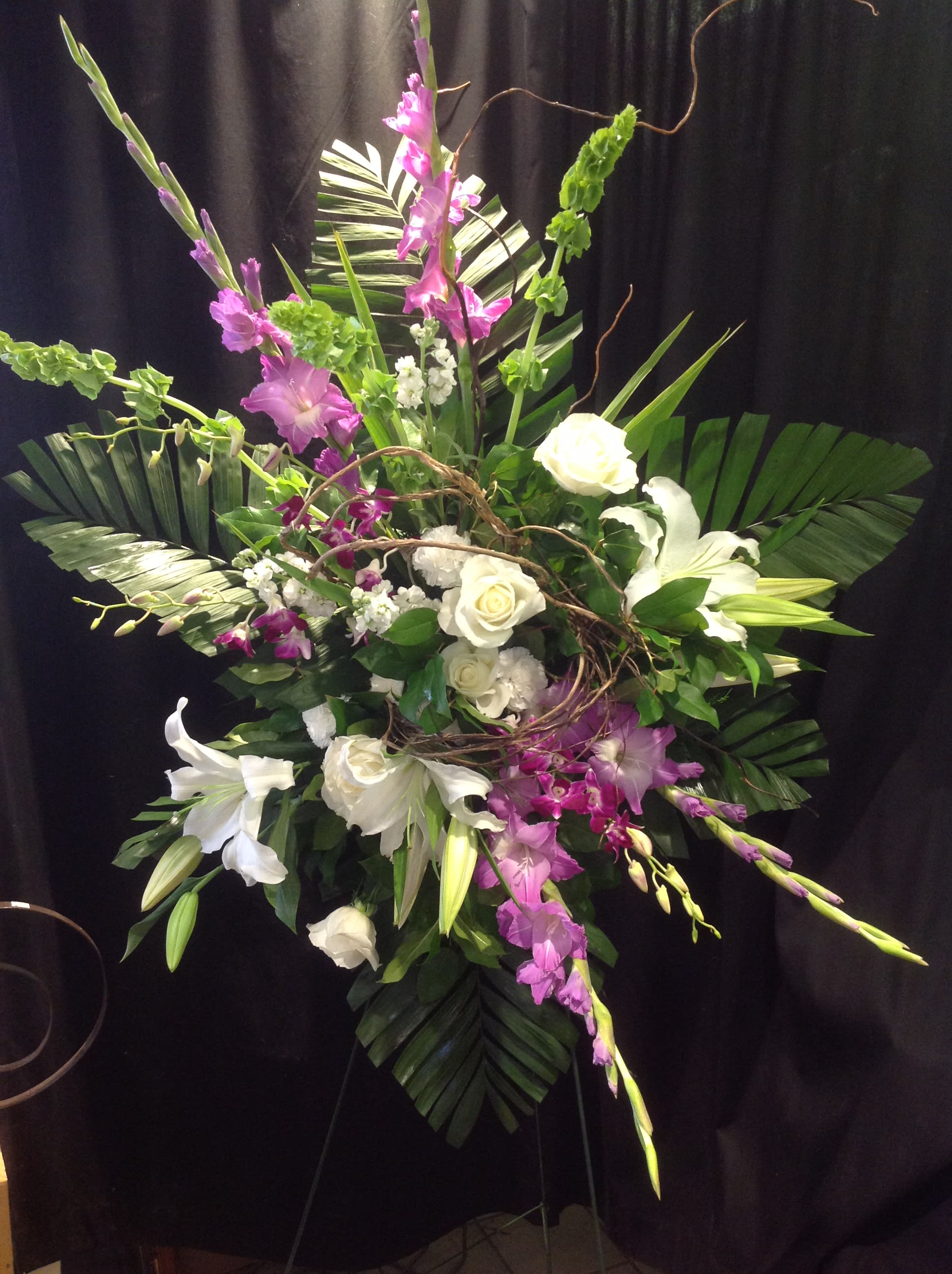 Sensitivity - Purple, white, and green tropical style flowers arranged in a standing spray.   *Flowers subject to change based on supply*