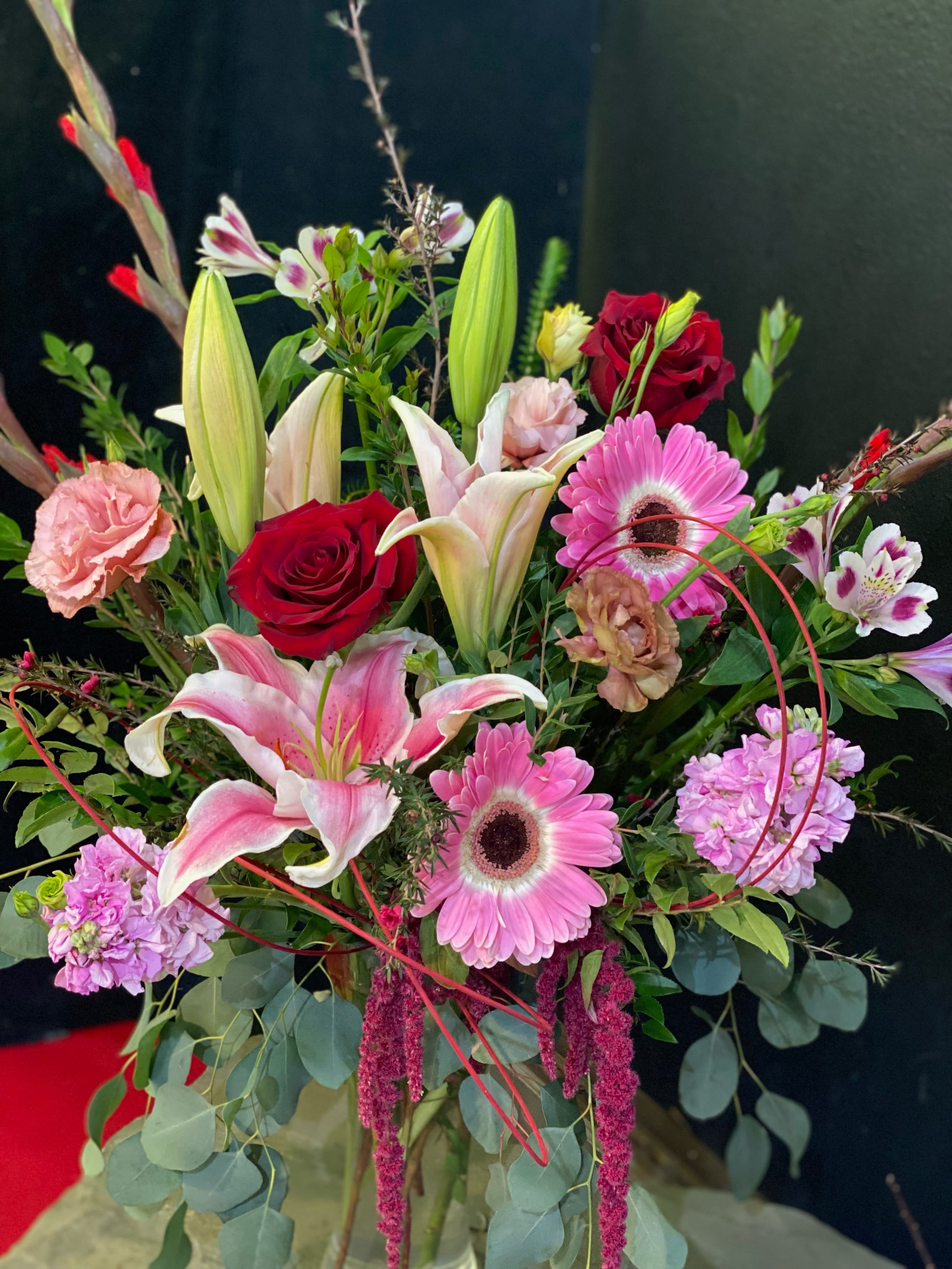 Mixed bouquet with pink lilies, red roses, and pink gerbera daisies