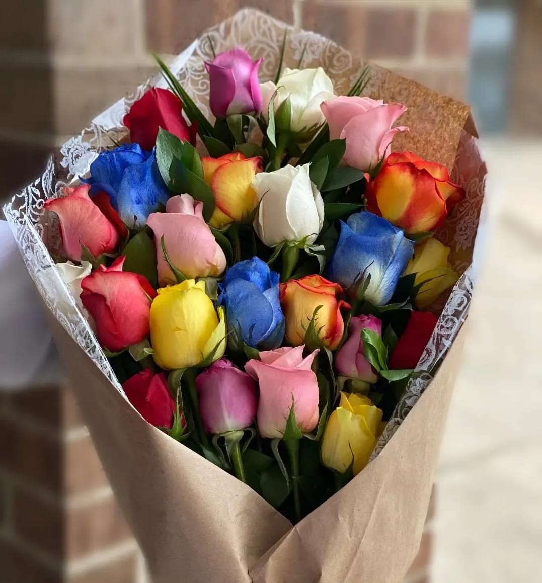 Bouquet of multicolored roses wrapped in brown paper