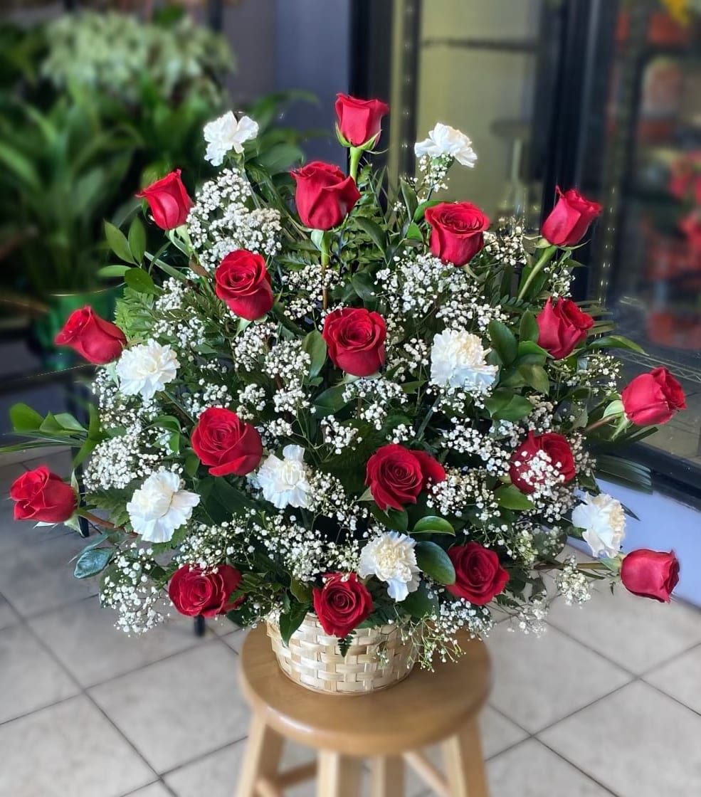 Red roses and white carnations in a woven basket