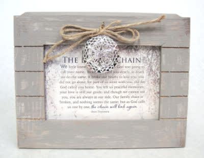 Framed memorial sign with a twine bow and decorative ornament