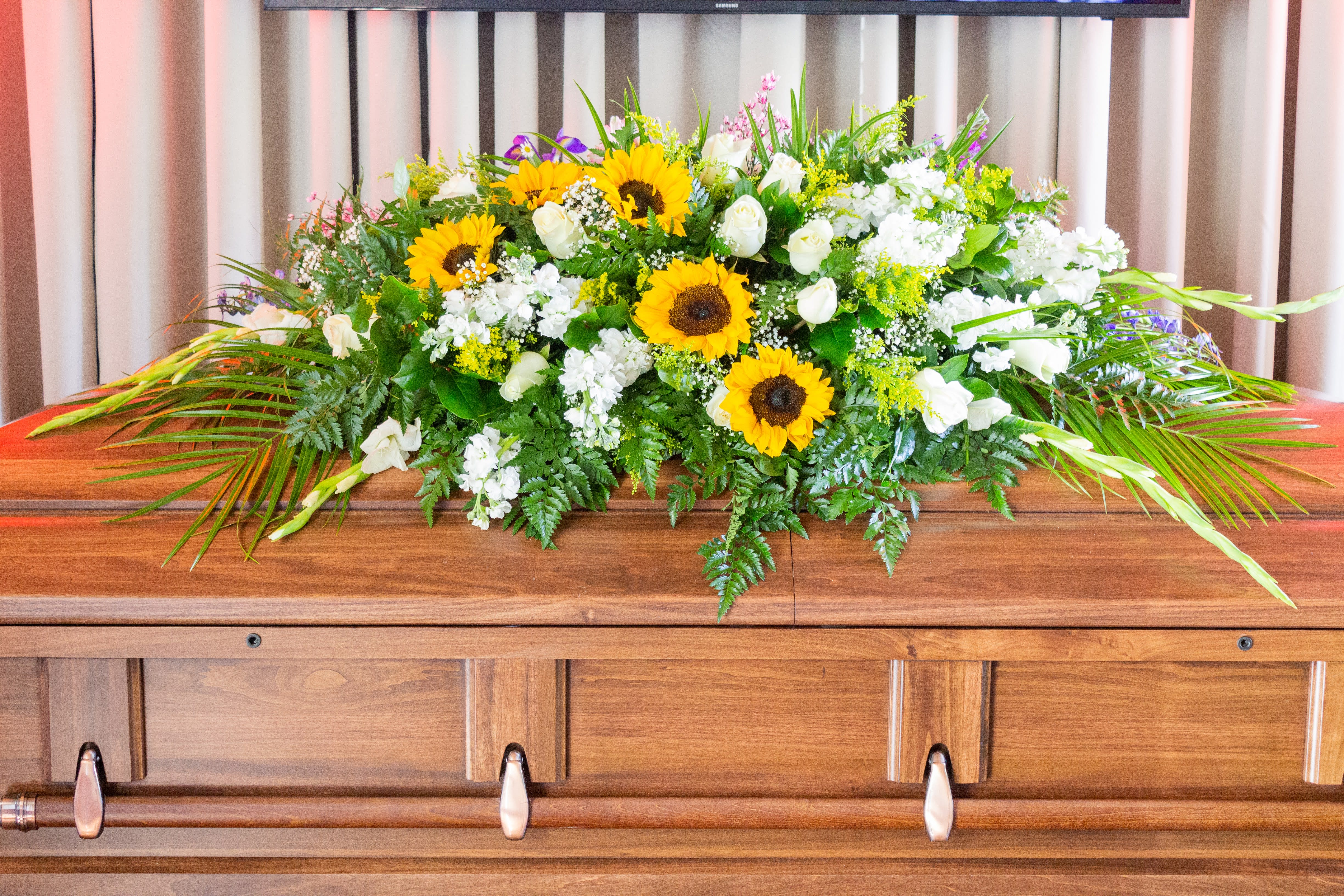 Sunflower and white floral casket spray with greenery