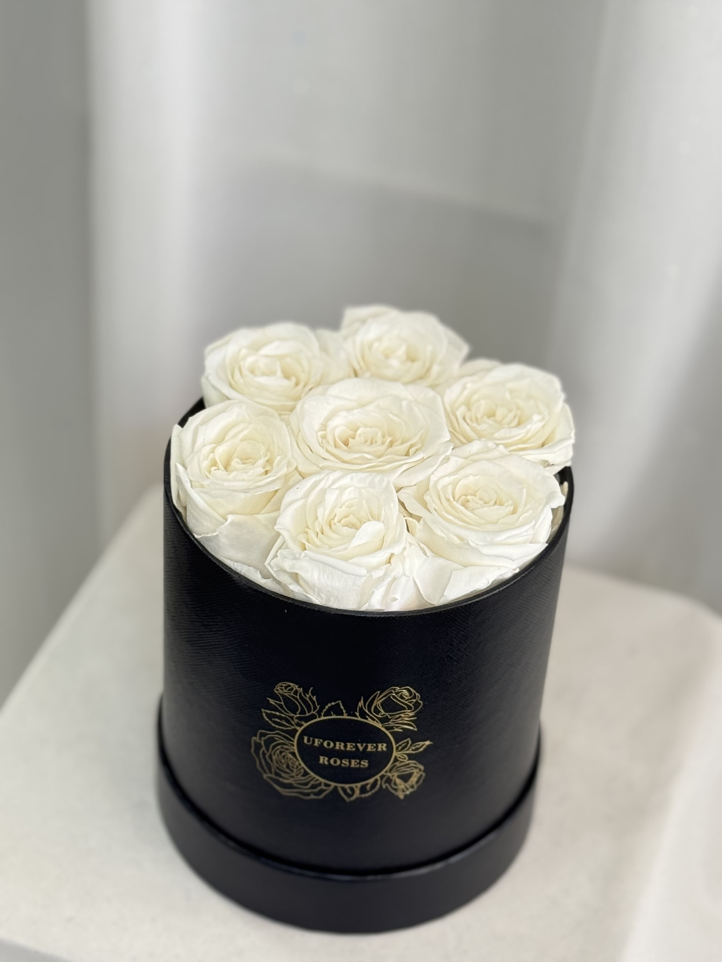  Forever Roses in White - A lasting luxurious gift of roses, that will impress your special someone and bring them joy every time they see them.  A beautifully quality preserved rose chosen at the peak of perfection and then preserved to maintain the original natural beauty of each unique rose. A luxurious and romantic gift of love and adoration to cherish over time. They are preserved and, with proper care, will stay just as beautiful for up to a year or longer.  Care Instructions: Arrangements do not require watering; for maximum beauty, keep away from extreme sunlight &amp; humidity  Roses and hat box arrive inside a decorative gift box with ribbon.  Item dimensions Height x Diameter: 7in x 5.5in 7 White Roses 