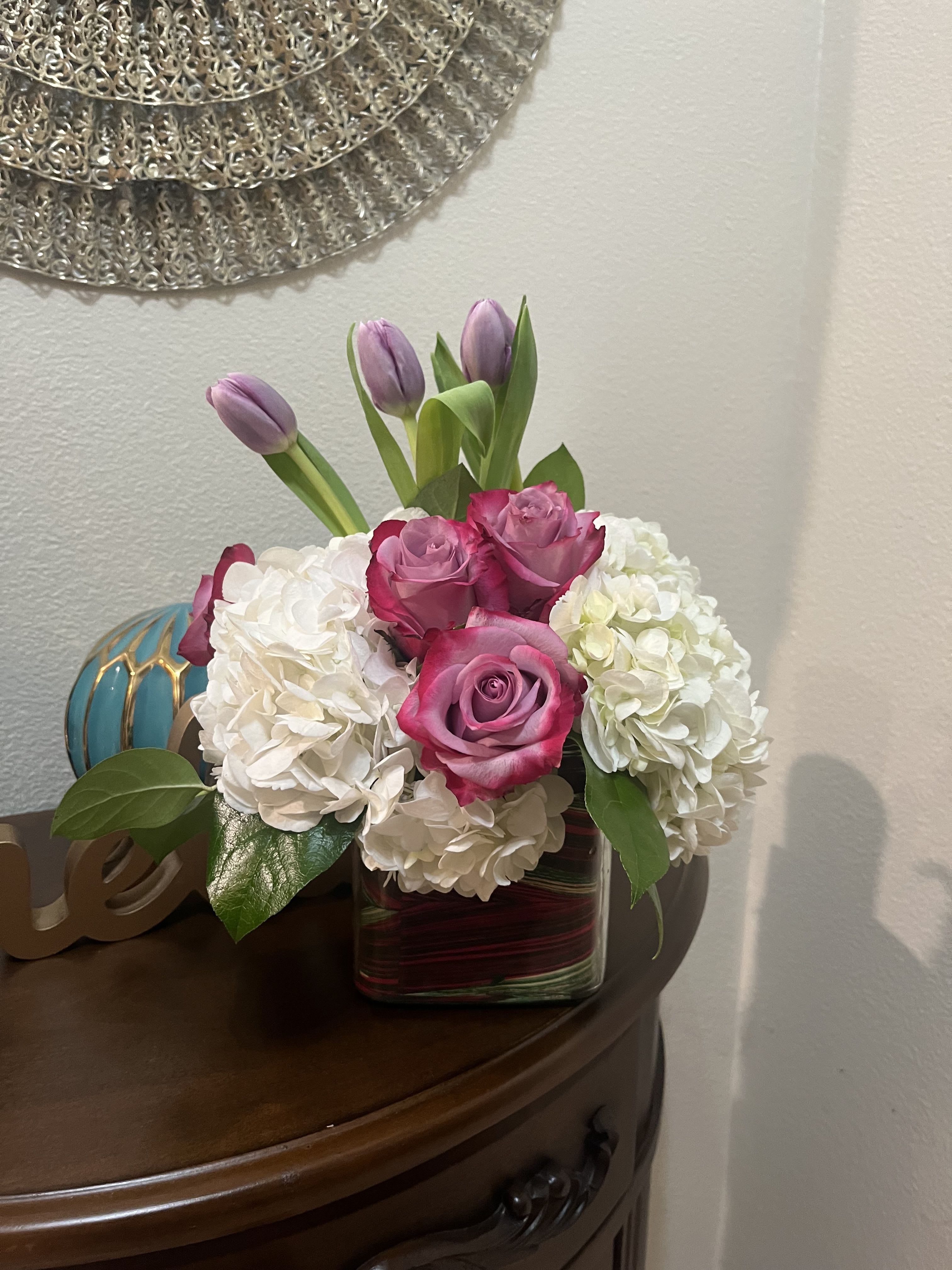 Here for You by BloomNation™ - Express your condolences after the loss of a loved one with flowers. Sending this clean purple and white arrangement featuring lavender roses and white hydrangea is a way to show you care and are thinking of them.  Approximate Dimensions: 11"D x 11"H