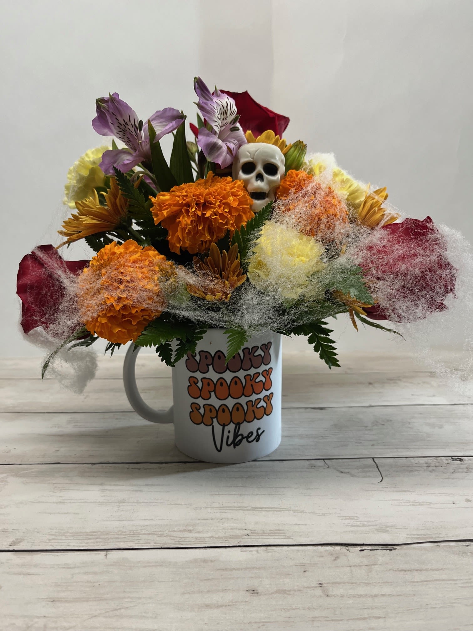 Halloween bouquet in a mug with a skull and colorful flowers