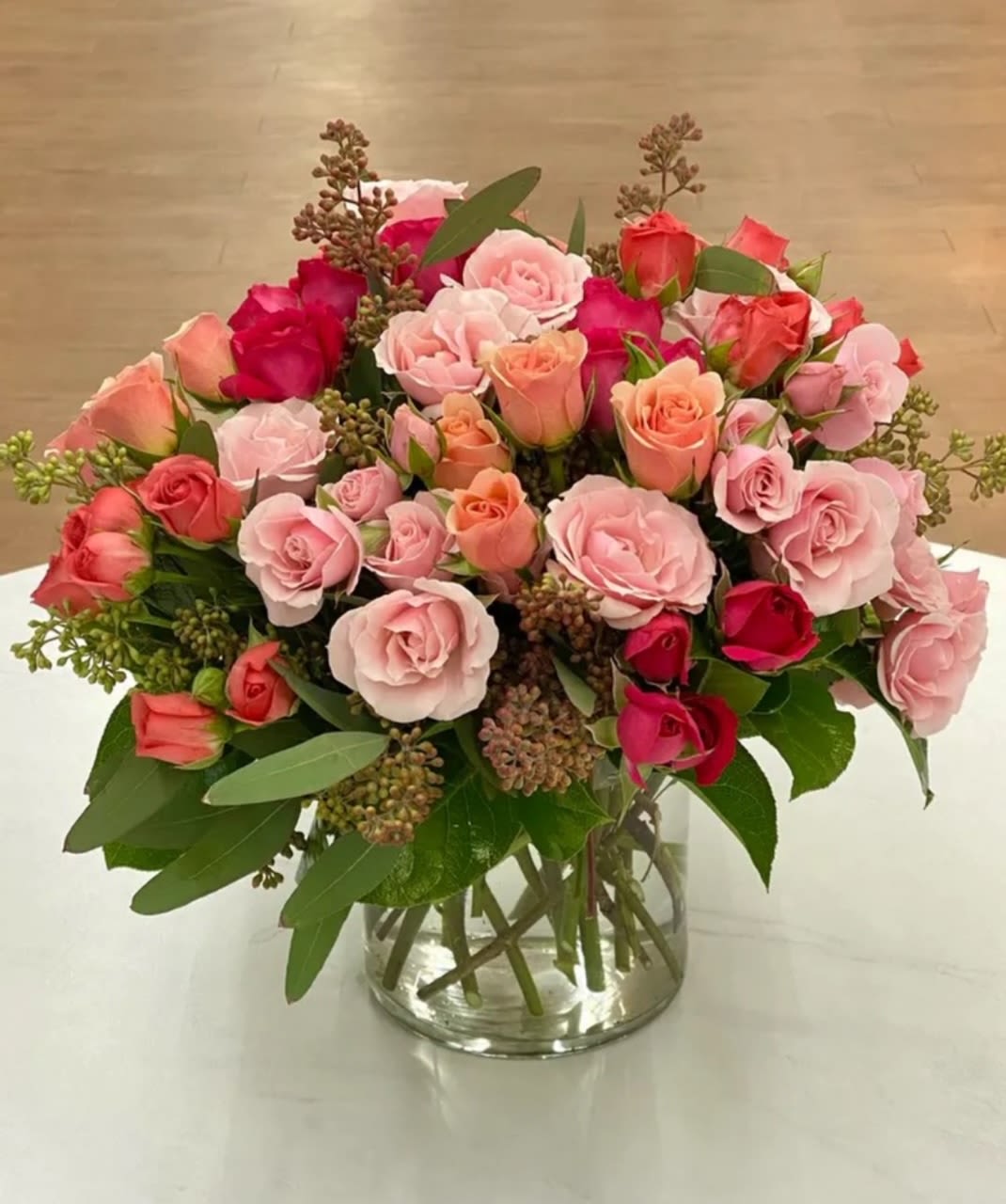 Bouquet of pink and coral roses in a clear glass vase