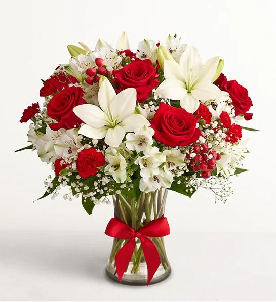 Fields of Europe® Bliss - That feeling of bliss, captured in a bouquet. Inspired by the beauty of the European countryside, our best seller brings together radiant roses and lush lilies in a glass vase wrapped in red ribbon. Whatever your reason for reaching out, it’s a gift that delivers on delight.