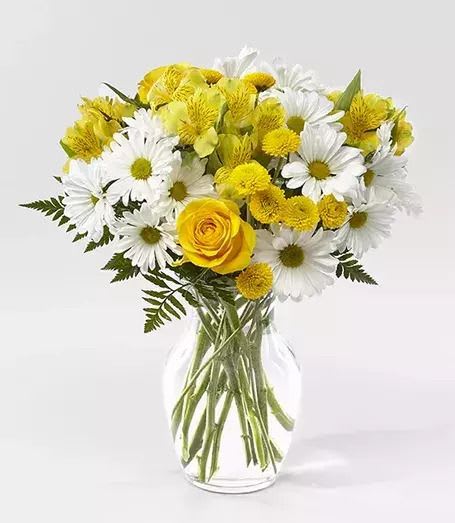 Dancing Daisies  - Loose cluster of white daisies, yellow blooms and a single yellow rose in a clear glass vase - cheerful, fresh