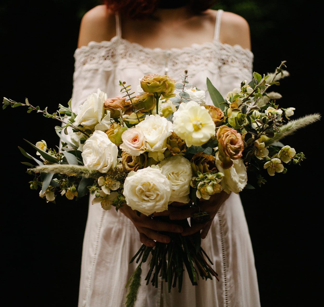 Bride holding a loose bouquet of cream and blush roses