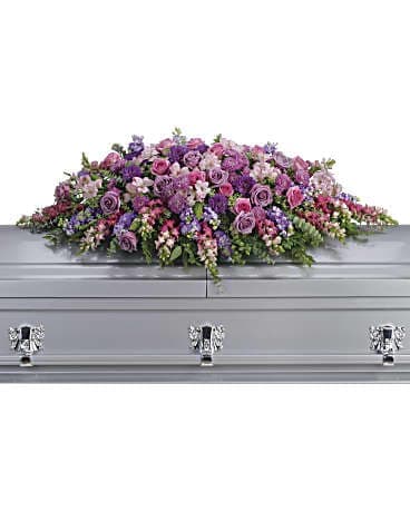Lavender and pink floral casket spray on a silver casket