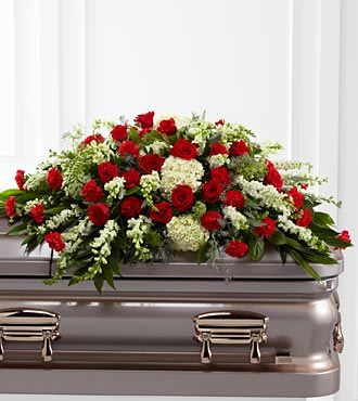Red roses and white flowers arranged on a casket