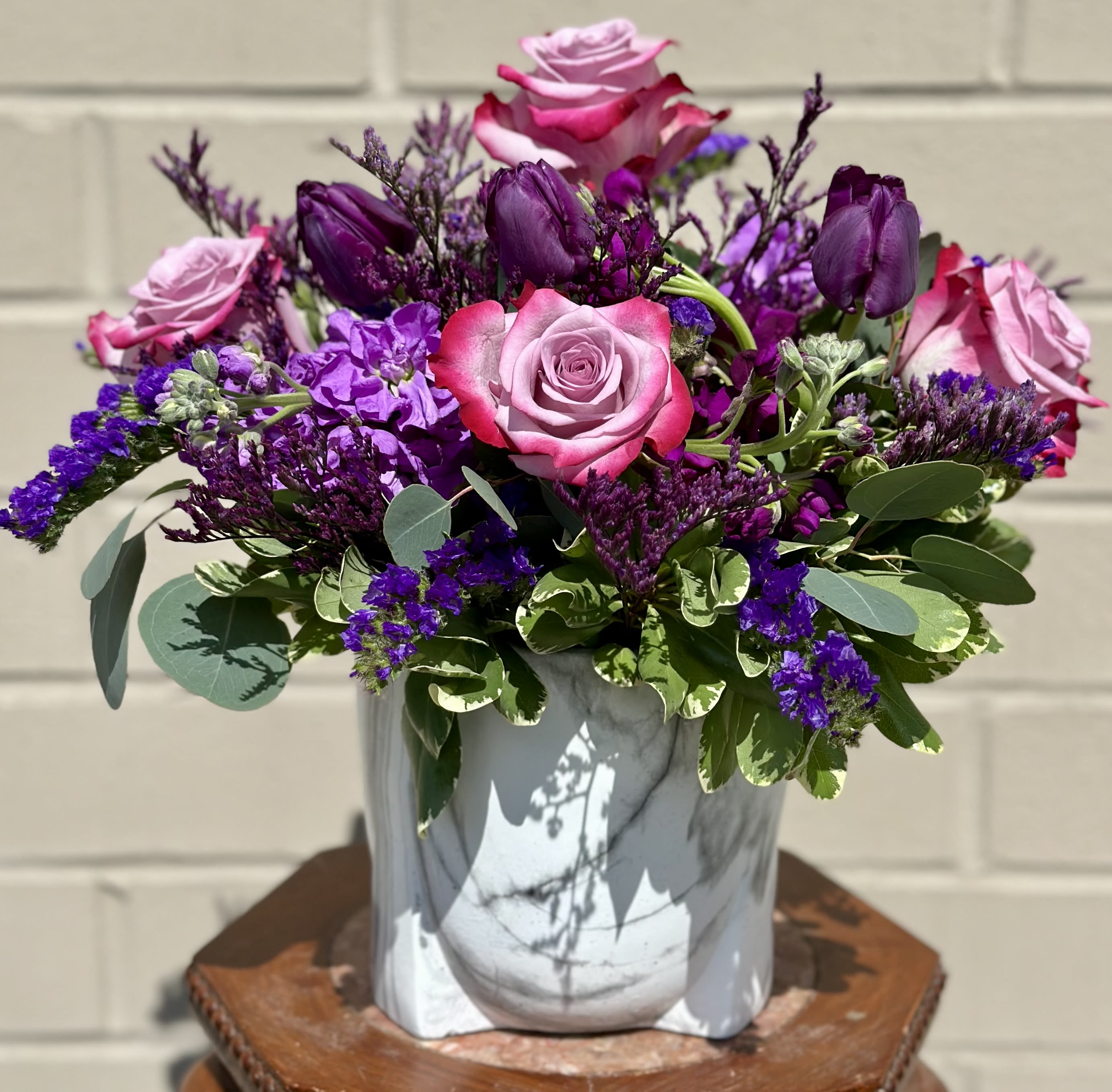 Pink and purple rose bouquet in a gray vase