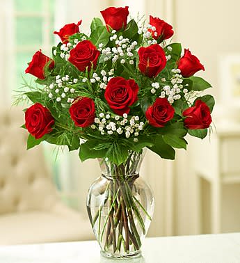 Red roses and baby's breath in a clear glass vase