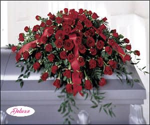  Dearly Departed  - Dearly Departed is a timeless casket cover created to honor a cherished life with love, dignity, and heartfelt remembrance. This elegant floral tribute features a stunning arrangement of rich red roses accented with graceful Italian ruscus greenery, creating a classic expression of devotion, admiration, and respect. The deep red roses symbolize everlasting love, courage, and the treasured memories that remain forever in our hearts, while the lush greenery adds a touch of natural beauty and grace. Handcrafted by our compassionate florists, Dearly Departed is a meaningful tribute designed to celebrate a loved one’s life and provide comfort to family and friends during a time of loss.