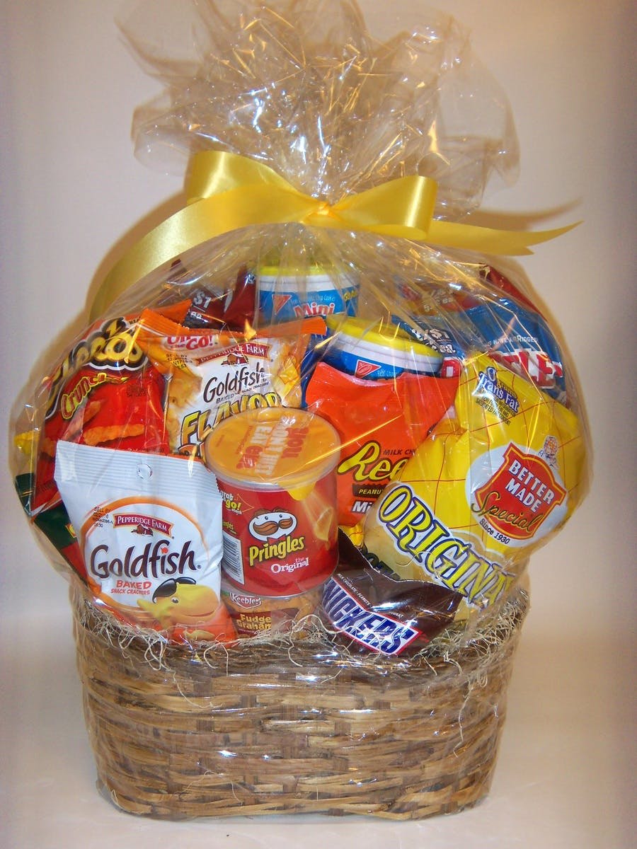 Basket of assorted snack foods wrapped in clear cellophane with a yellow bow