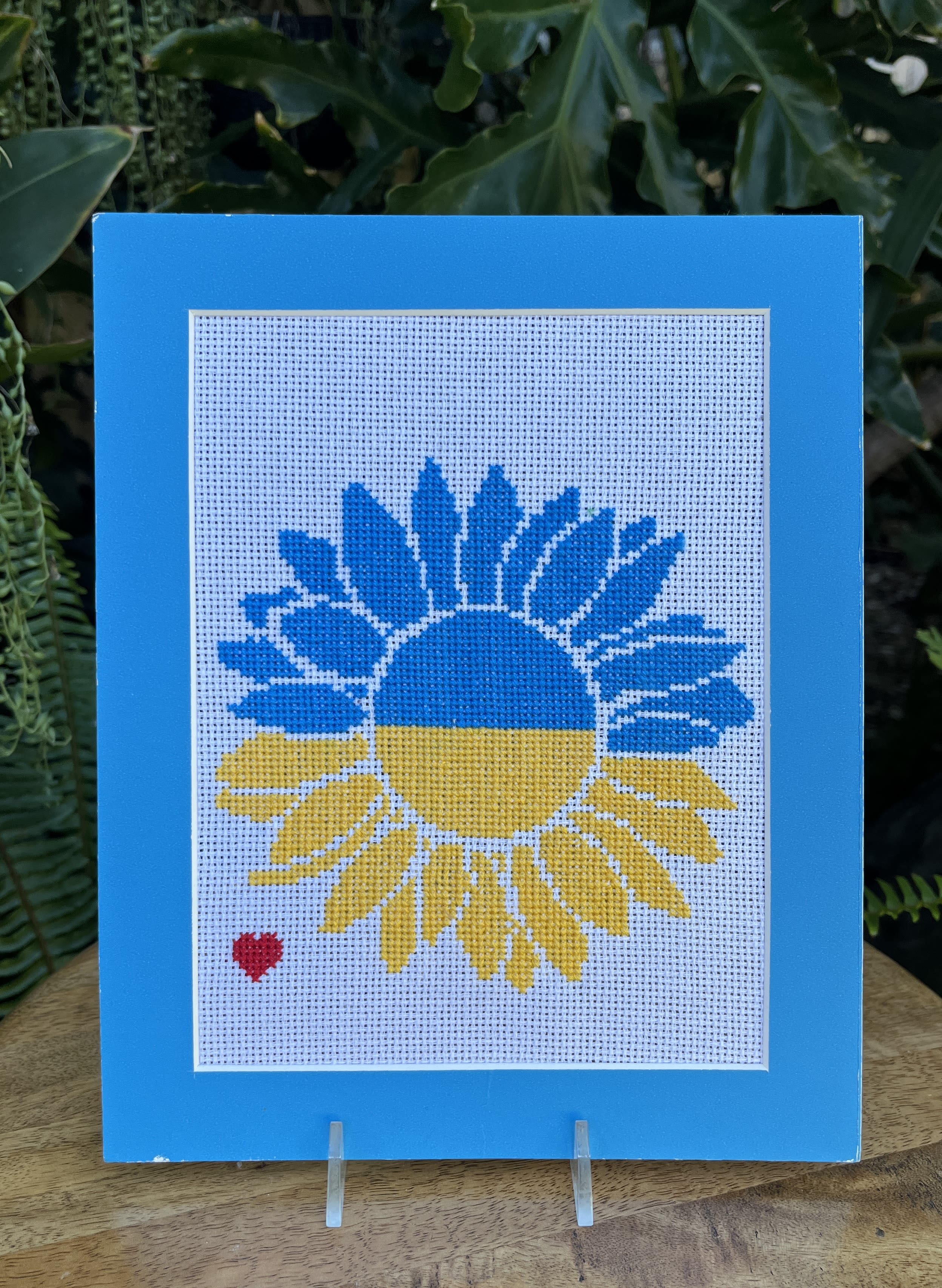 Blue and yellow sunflower design on a framed needlepoint panel