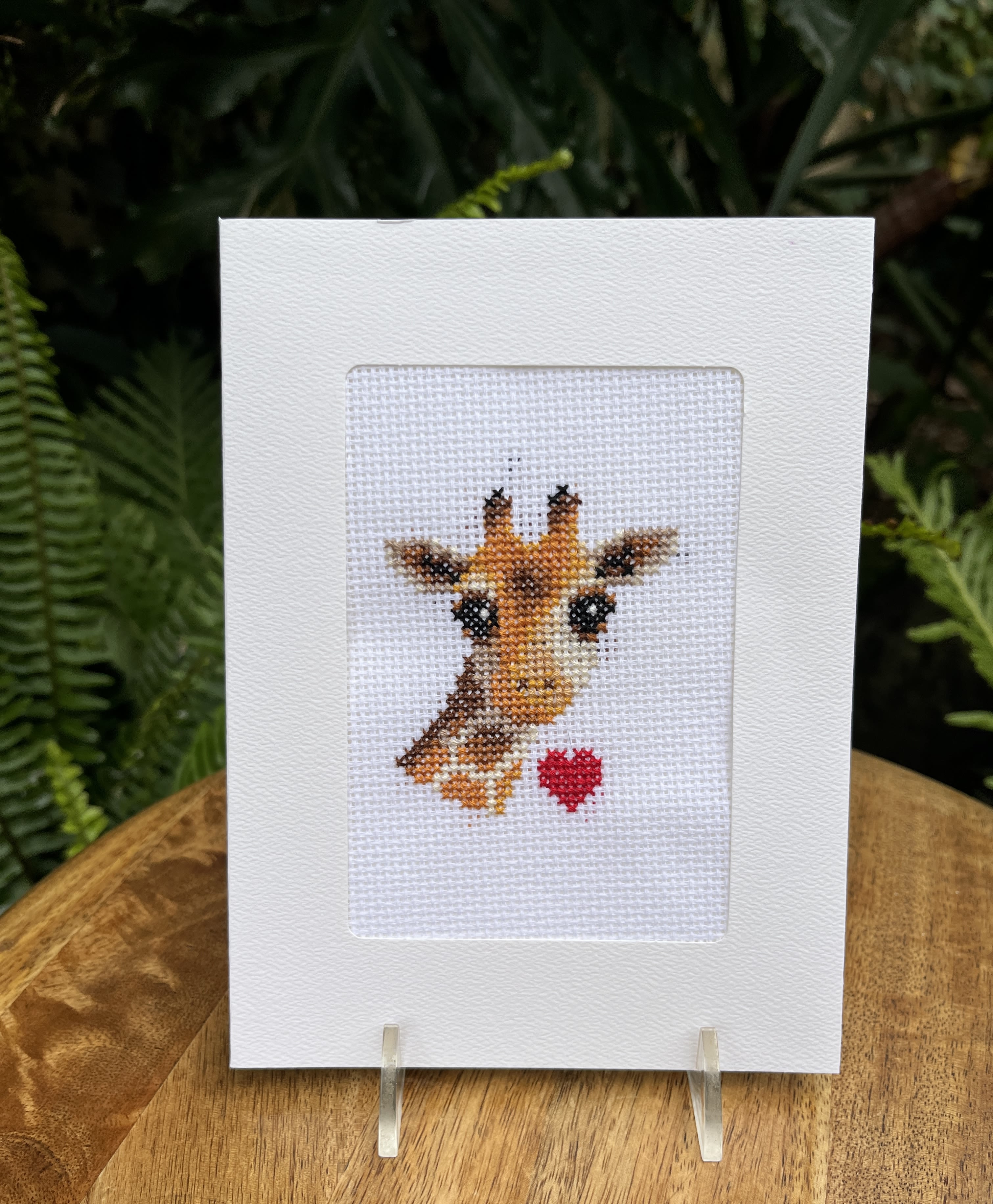 Cross-stitch greeting card with a giraffe and red heart
