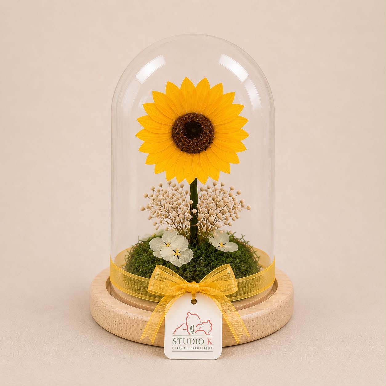 Forever Sunflower Dome (Height: 9.84 ") - A real Ecuadorian sunflower, professionally preserved to maintain its natural beauty for years. Elegantly displayed under a clear glass dome and accented with delicate preserved botanicals and natural moss, this piece captures warmth, joy, and timeless charm.  Known for their vibrant color and exceptional quality, Ecuadorian sunflowers bring a radiant, uplifting presence to any space. Maintenance-free and designed to last, this floral keepsake is perfect as a meaningful gift or a refined decorative statement.  Each piece is Designer’s Choice. Sunflower size and tones may vary slightly based on availability while preserving the overall look, quality, and presentation.  Perfect for birthdays, get well wishes, thank you gestures, thinking of you, Mother’s Day, or as a bright and uplifting home décor accent.  Available for delivery in Southwest Florida, including Naples, Bonita Springs, and Fort Myers Beach. 