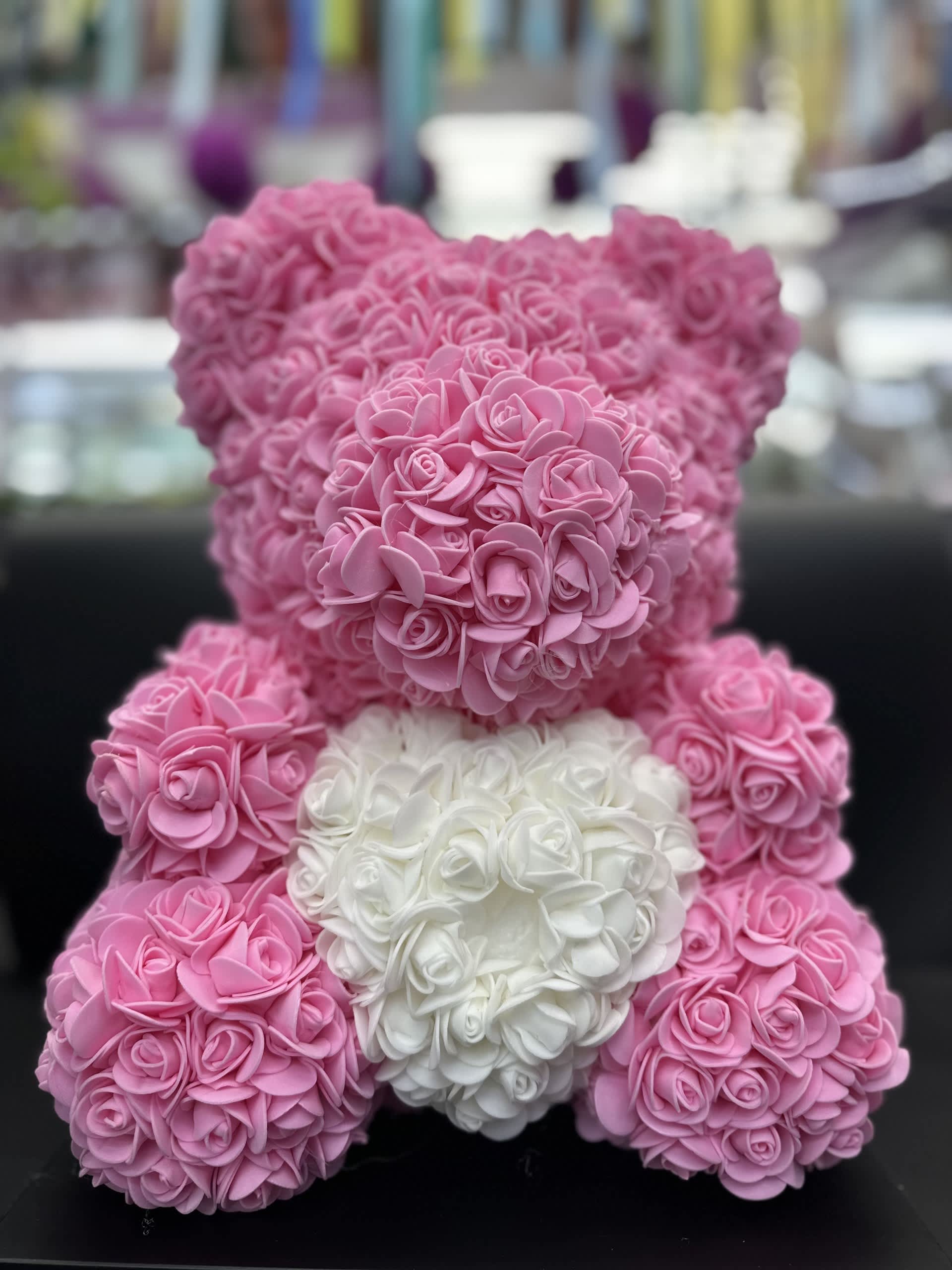 Pink and white teddy bear made of small rose-like flowers