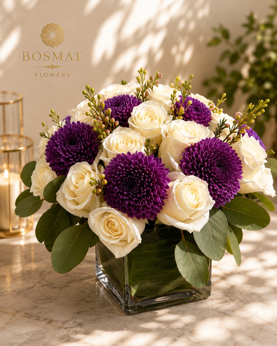 Royal Harmony - Creamy white roses and vivid purple chrysanthemums form a compact, rounded bouquet that reads as romantic yet modern-perfect as a birthday bouquet or a "just because" surprise that makes someone feel truly seen. The pink and green accents lift the palette into a softer harmony, so this arrangement also works beautifully for Mother's Day or an intimate anniversary.  Arranged low in a clear square glass vase, Royal Harmony includes hydrangeas, stock, and chrysanthemums layered with broad eucalyptus-like foliage and small berry-like or filler sprigs for texture and depth. The finished piece measures as a tasteful tabletop size that fits well on a dining table or desk; its polished white-and-purple contrast creates a refined, celebratory impression without being over-the-top.  Give this to the person you want to celebrate today-she'll feel cherished, calm, and noticed. For best enjoyment, keep the water fresh and trim stems every few days; if ordering for a specific date, select delivery instructions at checkout to ensure it arrives at the right moment.