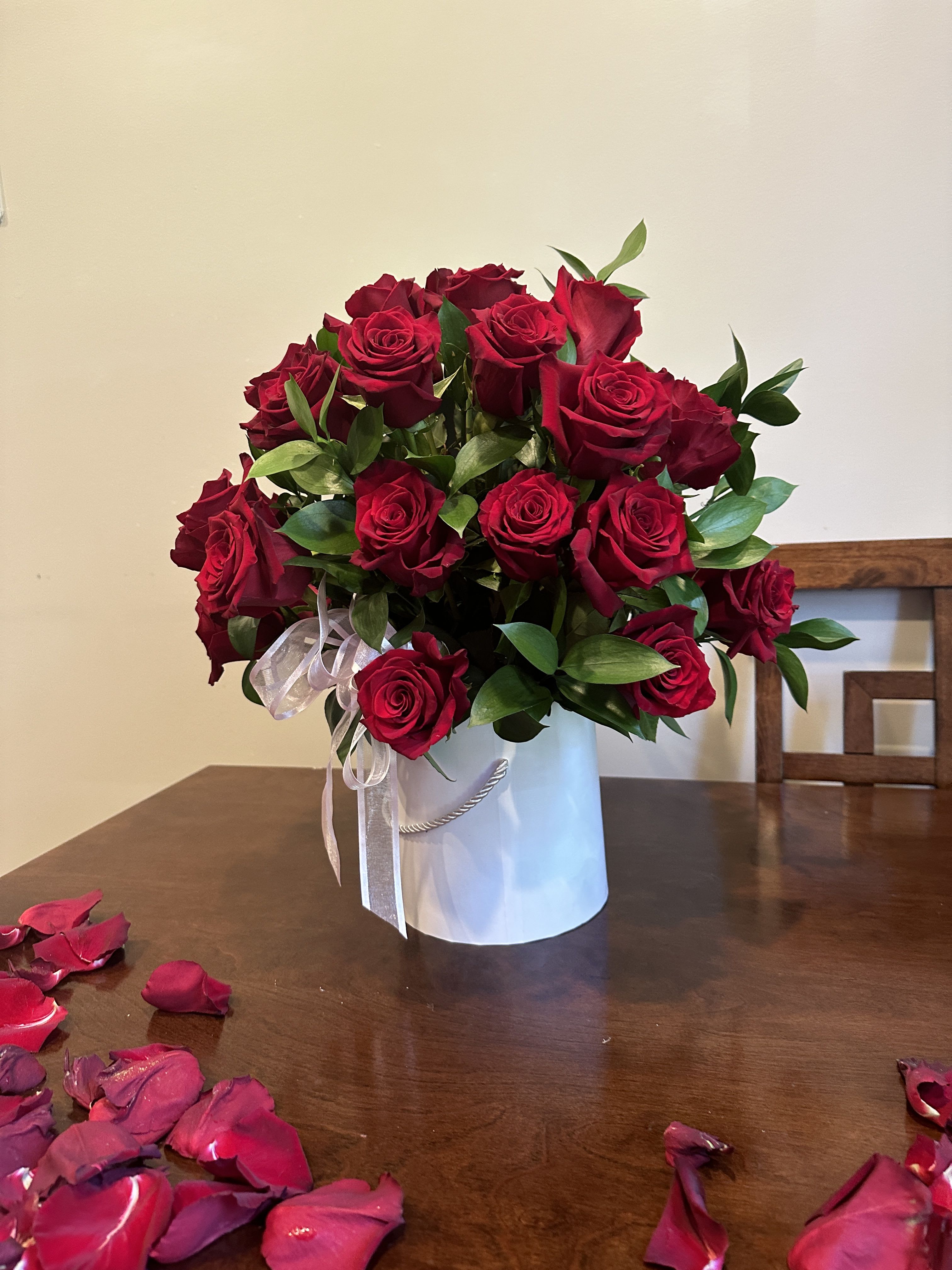 Bouquet of red roses in a white hatbox with a ribbon