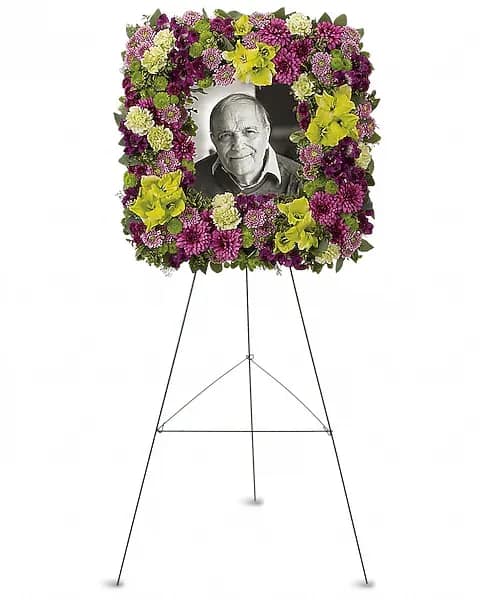 Mosaic of Memories Square Easel Wreath - A unique and lovely tribute for the service, this contemporary square easel wreath of purple and green flowers is a gift of caring expressed with beauty and style. The elegant arrangement includes purple alstroemeria, green gladioli, green carnations, purple cushion spray chrysanthemums, lavender button spray chrysanthemums, green button spray chrysanthemums and purple button spray chrysanthemums, accented with assorted greenery.  